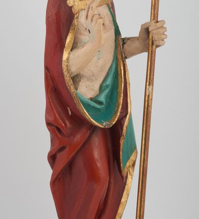 Zdjęcie nr 3: Figura Chrystusa pełnoplastyczna, ustawiona na podstawie na planie ośmioboku oraz na rzeźbionym fragmencie podłoża. Chrystus zwrócony jest frontalnie, w lekkim kontrapoście. Prawą rękę unosi w geście błogosławieństwa, w lewej trzyma drzewce czerwonej chorągwi z tkaniny z naszytym krzyżem, ujętej dwoma chwostami. Twarz ma pociągłą z wysokim czołem, migdałowatymi oczami, wąskim i zadartym nosem oraz małymi ustami, okoloną krótką, falowaną brodą rozdzieloną na dwoje oraz regularnie falowanymi włosami sięgającymi ramion. Ubrany jest w czerwony płaszcz z zieloną podszewką i złoconą lamówką, zapięty na piersi, opadający na plecy i ramiona, zawinięty łukowato z przodu postaci, odsłaniający nagi tors i lewą nogę. Polichromia ciała naturalistyczna z zaznaczonymi śladami męki.