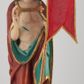Zdjęcie nr 1: Figura Chrystusa pełnoplastyczna, ustawiona na podstawie na planie ośmioboku oraz na rzeźbionym fragmencie podłoża. Chrystus zwrócony jest frontalnie, w lekkim kontrapoście. Prawą rękę unosi w geście błogosławieństwa, w lewej trzyma drzewce czerwonej chorągwi z tkaniny z naszytym krzyżem, ujętej dwoma chwostami. Twarz ma pociągłą z wysokim czołem, migdałowatymi oczami, wąskim i zadartym nosem oraz małymi ustami, okoloną krótką, falowaną brodą rozdzieloną na dwoje oraz regularnie falowanymi włosami sięgającymi ramion. Ubrany jest w czerwony płaszcz z zieloną podszewką i złoconą lamówką, zapięty na piersi, opadający na plecy i ramiona, zawinięty łukowato z przodu postaci, odsłaniający nagi tors i lewą nogę. Polichromia ciała naturalistyczna z zaznaczonymi śladami męki.