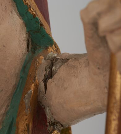 Zdjęcie nr 8: Figura Chrystusa pełnoplastyczna, ustawiona na podstawie na planie ośmioboku oraz na rzeźbionym fragmencie podłoża. Chrystus zwrócony jest frontalnie, w lekkim kontrapoście. Prawą rękę unosi w geście błogosławieństwa, w lewej trzyma drzewce czerwonej chorągwi z tkaniny z naszytym krzyżem, ujętej dwoma chwostami. Twarz ma pociągłą z wysokim czołem, migdałowatymi oczami, wąskim i zadartym nosem oraz małymi ustami, okoloną krótką, falowaną brodą rozdzieloną na dwoje oraz regularnie falowanymi włosami sięgającymi ramion. Ubrany jest w czerwony płaszcz z zieloną podszewką i złoconą lamówką, zapięty na piersi, opadający na plecy i ramiona, zawinięty łukowato z przodu postaci, odsłaniający nagi tors i lewą nogę. Polichromia ciała naturalistyczna z zaznaczonymi śladami męki.