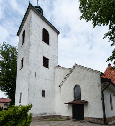 Zdjęcie nr 1: Kościół murowany z cegły i kamienia, tynkowany, orientowany, jednonawowy z kaplicami. Prezbiterium wydłużone, zamknięte trójbocznie, odchylone na południe od osi nawy, przy północnej ścianie niewielka, prostokątna dawna zakrystia (obecnie kruchta), przy południowej dobudowana wtórnie piętrowa dwuczęściowa zakrystia ze skarbcem, od wschodu, na zewnętrznej ścianie kościoła Ogrojec. Nawa główna szersza od prezbiterium, na rzucie prostokąta, od południa wieloboczna kaplica Najświętszego Serca Pana Jezusa (dawniej Przemienienia Pańskiego), od północy i południa dobudowane kaplice boczne na planie prostokąta, północna dwukrotnie większa od południowej, od zachodu wieża na planie kwadratu. Prezbiterium i nawa nakryte sklepieniami pozornymi, oddzielone od ścian gzymsem przebiegającym przez całe wnętrze, łuk tęczowy półkolisty, wewnątrz ujęty pilastrami. Dawne, ostrołukowe okna znajdują się w ścianach nawy głównej. Dostęp do kaplicy i naw bocznych z nawy głównej przez wysokie przejścia arkadowe, w północnej części nawy ujęte opaskami tynkowymi, w północno-zachodniej przejście z barokowym, kamiennym portalem (dawne wejście do kościoła). W starej zakrystii dwa gotyckie, kamienne, ostrołukowe portale oraz gotyckie okno. W wielobocznej kaplicy sklepienie kolebkowe z lunetami, w kaplicach bocznych oraz w nowej zakrystii stropy żelbetowe i sufity tynkowe. Elewacje tynkowane, z obłożoną kamieniem partią cokołu, ściana północna dawnej zakrystii z odsłoniętym wątkiem kamiennym oraz narożną przyporą, wieloboczna kaplica oszkarpowana w narożach. Do wschodniej ściany prezbiterium dobudowany kamienny Ogrójec z arkadą, zwieńczony gzymsem oraz schodkowym szczytem z kamiennymi figurami. Wejścia do kościoła przez kaplice boczne od północy i zachodu oraz przez kruchtę w przyziemiu wieży. Okna w formie stojącego prostokąta w ścianach kaplic bocznych, nowej zakrystii, prezbiterium, okna ostrołukowe w wielobocznej kaplicy. Wieża smukła, trójkondygnacyjna, bez podziałów architektonicznych z oknami na poziomie każdej kondygnacji, zwieńczona hełmem baniastym. Nawa główna i prezbiterium nakryte dachem dwuspadowym, niższe nawy boczne również. W miejscu połączenia nawy i prezbiterium wieżyczka na sygnaturkę. Kaplica przekryta dachem ostrosłupowym, nowa zakrystia i skarbiec dachem trójspadowym, stara zakrystia pulpitowym. 
