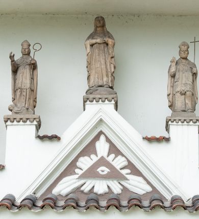 Zdjęcie nr 4: Kościół murowany z cegły i kamienia, tynkowany, orientowany, jednonawowy z kaplicami. Prezbiterium wydłużone, zamknięte trójbocznie, odchylone na południe od osi nawy, przy północnej ścianie niewielka, prostokątna dawna zakrystia (obecnie kruchta), przy południowej dobudowana wtórnie piętrowa dwuczęściowa zakrystia ze skarbcem, od wschodu, na zewnętrznej ścianie kościoła Ogrojec. Nawa główna szersza od prezbiterium, na rzucie prostokąta, od południa wieloboczna kaplica Najświętszego Serca Pana Jezusa (dawniej Przemienienia Pańskiego), od północy i południa dobudowane kaplice boczne na planie prostokąta, północna dwukrotnie większa od południowej, od zachodu wieża na planie kwadratu. Prezbiterium i nawa nakryte sklepieniami pozornymi, oddzielone od ścian gzymsem przebiegającym przez całe wnętrze, łuk tęczowy półkolisty, wewnątrz ujęty pilastrami. Dawne, ostrołukowe okna znajdują się w ścianach nawy głównej. Dostęp do kaplicy i naw bocznych z nawy głównej przez wysokie przejścia arkadowe, w północnej części nawy ujęte opaskami tynkowymi, w północno-zachodniej przejście z barokowym, kamiennym portalem (dawne wejście do kościoła). W starej zakrystii dwa gotyckie, kamienne, ostrołukowe portale oraz gotyckie okno. W wielobocznej kaplicy sklepienie kolebkowe z lunetami, w kaplicach bocznych oraz w nowej zakrystii stropy żelbetowe i sufity tynkowe. Elewacje tynkowane, z obłożoną kamieniem partią cokołu, ściana północna dawnej zakrystii z odsłoniętym wątkiem kamiennym oraz narożną przyporą, wieloboczna kaplica oszkarpowana w narożach. Do wschodniej ściany prezbiterium dobudowany kamienny Ogrójec z arkadą, zwieńczony gzymsem oraz schodkowym szczytem z kamiennymi figurami. Wejścia do kościoła przez kaplice boczne od północy i zachodu oraz przez kruchtę w przyziemiu wieży. Okna w formie stojącego prostokąta w ścianach kaplic bocznych, nowej zakrystii, prezbiterium, okna ostrołukowe w wielobocznej kaplicy. Wieża smukła, trójkondygnacyjna, bez podziałów architektonicznych z oknami na poziomie każdej kondygnacji, zwieńczona hełmem baniastym. Nawa główna i prezbiterium nakryte dachem dwuspadowym, niższe nawy boczne również. W miejscu połączenia nawy i prezbiterium wieżyczka na sygnaturkę. Kaplica przekryta dachem ostrosłupowym, nowa zakrystia i skarbiec dachem trójspadowym, stara zakrystia pulpitowym. 
