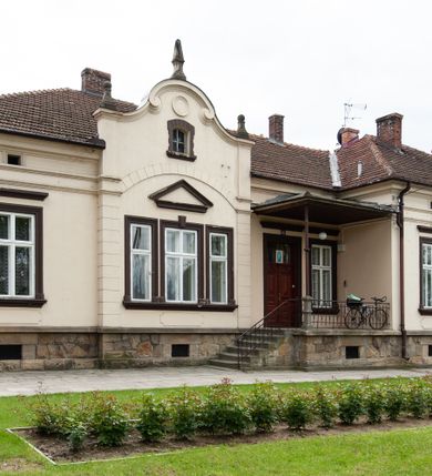 Zdjęcie nr 14: Kościół murowany z cegły i kamienia, tynkowany, orientowany, jednonawowy z kaplicami. Prezbiterium wydłużone, zamknięte trójbocznie, odchylone na południe od osi nawy, przy północnej ścianie niewielka, prostokątna dawna zakrystia (obecnie kruchta), przy południowej dobudowana wtórnie piętrowa dwuczęściowa zakrystia ze skarbcem, od wschodu, na zewnętrznej ścianie kościoła Ogrojec. Nawa główna szersza od prezbiterium, na rzucie prostokąta, od południa wieloboczna kaplica Najświętszego Serca Pana Jezusa (dawniej Przemienienia Pańskiego), od północy i południa dobudowane kaplice boczne na planie prostokąta, północna dwukrotnie większa od południowej, od zachodu wieża na planie kwadratu. Prezbiterium i nawa nakryte sklepieniami pozornymi, oddzielone od ścian gzymsem przebiegającym przez całe wnętrze, łuk tęczowy półkolisty, wewnątrz ujęty pilastrami. Dawne, ostrołukowe okna znajdują się w ścianach nawy głównej. Dostęp do kaplicy i naw bocznych z nawy głównej przez wysokie przejścia arkadowe, w północnej części nawy ujęte opaskami tynkowymi, w północno-zachodniej przejście z barokowym, kamiennym portalem (dawne wejście do kościoła). W starej zakrystii dwa gotyckie, kamienne, ostrołukowe portale oraz gotyckie okno. W wielobocznej kaplicy sklepienie kolebkowe z lunetami, w kaplicach bocznych oraz w nowej zakrystii stropy żelbetowe i sufity tynkowe. Elewacje tynkowane, z obłożoną kamieniem partią cokołu, ściana północna dawnej zakrystii z odsłoniętym wątkiem kamiennym oraz narożną przyporą, wieloboczna kaplica oszkarpowana w narożach. Do wschodniej ściany prezbiterium dobudowany kamienny Ogrójec z arkadą, zwieńczony gzymsem oraz schodkowym szczytem z kamiennymi figurami. Wejścia do kościoła przez kaplice boczne od północy i zachodu oraz przez kruchtę w przyziemiu wieży. Okna w formie stojącego prostokąta w ścianach kaplic bocznych, nowej zakrystii, prezbiterium, okna ostrołukowe w wielobocznej kaplicy. Wieża smukła, trójkondygnacyjna, bez podziałów architektonicznych z oknami na poziomie każdej kondygnacji, zwieńczona hełmem baniastym. Nawa główna i prezbiterium nakryte dachem dwuspadowym, niższe nawy boczne również. W miejscu połączenia nawy i prezbiterium wieżyczka na sygnaturkę. Kaplica przekryta dachem ostrosłupowym, nowa zakrystia i skarbiec dachem trójspadowym, stara zakrystia pulpitowym. 
