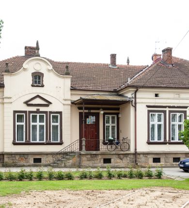 Zdjęcie nr 15: Kościół murowany z cegły i kamienia, tynkowany, orientowany, jednonawowy z kaplicami. Prezbiterium wydłużone, zamknięte trójbocznie, odchylone na południe od osi nawy, przy północnej ścianie niewielka, prostokątna dawna zakrystia (obecnie kruchta), przy południowej dobudowana wtórnie piętrowa dwuczęściowa zakrystia ze skarbcem, od wschodu, na zewnętrznej ścianie kościoła Ogrojec. Nawa główna szersza od prezbiterium, na rzucie prostokąta, od południa wieloboczna kaplica Najświętszego Serca Pana Jezusa (dawniej Przemienienia Pańskiego), od północy i południa dobudowane kaplice boczne na planie prostokąta, północna dwukrotnie większa od południowej, od zachodu wieża na planie kwadratu. Prezbiterium i nawa nakryte sklepieniami pozornymi, oddzielone od ścian gzymsem przebiegającym przez całe wnętrze, łuk tęczowy półkolisty, wewnątrz ujęty pilastrami. Dawne, ostrołukowe okna znajdują się w ścianach nawy głównej. Dostęp do kaplicy i naw bocznych z nawy głównej przez wysokie przejścia arkadowe, w północnej części nawy ujęte opaskami tynkowymi, w północno-zachodniej przejście z barokowym, kamiennym portalem (dawne wejście do kościoła). W starej zakrystii dwa gotyckie, kamienne, ostrołukowe portale oraz gotyckie okno. W wielobocznej kaplicy sklepienie kolebkowe z lunetami, w kaplicach bocznych oraz w nowej zakrystii stropy żelbetowe i sufity tynkowe. Elewacje tynkowane, z obłożoną kamieniem partią cokołu, ściana północna dawnej zakrystii z odsłoniętym wątkiem kamiennym oraz narożną przyporą, wieloboczna kaplica oszkarpowana w narożach. Do wschodniej ściany prezbiterium dobudowany kamienny Ogrójec z arkadą, zwieńczony gzymsem oraz schodkowym szczytem z kamiennymi figurami. Wejścia do kościoła przez kaplice boczne od północy i zachodu oraz przez kruchtę w przyziemiu wieży. Okna w formie stojącego prostokąta w ścianach kaplic bocznych, nowej zakrystii, prezbiterium, okna ostrołukowe w wielobocznej kaplicy. Wieża smukła, trójkondygnacyjna, bez podziałów architektonicznych z oknami na poziomie każdej kondygnacji, zwieńczona hełmem baniastym. Nawa główna i prezbiterium nakryte dachem dwuspadowym, niższe nawy boczne również. W miejscu połączenia nawy i prezbiterium wieżyczka na sygnaturkę. Kaplica przekryta dachem ostrosłupowym, nowa zakrystia i skarbiec dachem trójspadowym, stara zakrystia pulpitowym. 
