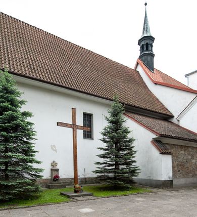 Zdjęcie nr 21: Kościół murowany z cegły i kamienia, tynkowany, orientowany, jednonawowy z kaplicami. Prezbiterium wydłużone, zamknięte trójbocznie, odchylone na południe od osi nawy, przy północnej ścianie niewielka, prostokątna dawna zakrystia (obecnie kruchta), przy południowej dobudowana wtórnie piętrowa dwuczęściowa zakrystia ze skarbcem, od wschodu, na zewnętrznej ścianie kościoła Ogrojec. Nawa główna szersza od prezbiterium, na rzucie prostokąta, od południa wieloboczna kaplica Najświętszego Serca Pana Jezusa (dawniej Przemienienia Pańskiego), od północy i południa dobudowane kaplice boczne na planie prostokąta, północna dwukrotnie większa od południowej, od zachodu wieża na planie kwadratu. Prezbiterium i nawa nakryte sklepieniami pozornymi, oddzielone od ścian gzymsem przebiegającym przez całe wnętrze, łuk tęczowy półkolisty, wewnątrz ujęty pilastrami. Dawne, ostrołukowe okna znajdują się w ścianach nawy głównej. Dostęp do kaplicy i naw bocznych z nawy głównej przez wysokie przejścia arkadowe, w północnej części nawy ujęte opaskami tynkowymi, w północno-zachodniej przejście z barokowym, kamiennym portalem (dawne wejście do kościoła). W starej zakrystii dwa gotyckie, kamienne, ostrołukowe portale oraz gotyckie okno. W wielobocznej kaplicy sklepienie kolebkowe z lunetami, w kaplicach bocznych oraz w nowej zakrystii stropy żelbetowe i sufity tynkowe. Elewacje tynkowane, z obłożoną kamieniem partią cokołu, ściana północna dawnej zakrystii z odsłoniętym wątkiem kamiennym oraz narożną przyporą, wieloboczna kaplica oszkarpowana w narożach. Do wschodniej ściany prezbiterium dobudowany kamienny Ogrójec z arkadą, zwieńczony gzymsem oraz schodkowym szczytem z kamiennymi figurami. Wejścia do kościoła przez kaplice boczne od północy i zachodu oraz przez kruchtę w przyziemiu wieży. Okna w formie stojącego prostokąta w ścianach kaplic bocznych, nowej zakrystii, prezbiterium, okna ostrołukowe w wielobocznej kaplicy. Wieża smukła, trójkondygnacyjna, bez podziałów architektonicznych z oknami na poziomie każdej kondygnacji, zwieńczona hełmem baniastym. Nawa główna i prezbiterium nakryte dachem dwuspadowym, niższe nawy boczne również. W miejscu połączenia nawy i prezbiterium wieżyczka na sygnaturkę. Kaplica przekryta dachem ostrosłupowym, nowa zakrystia i skarbiec dachem trójspadowym, stara zakrystia pulpitowym. 
