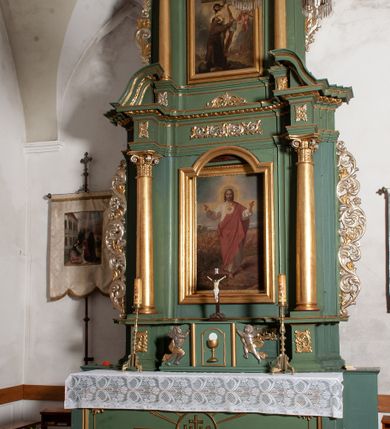 Zdjęcie nr 13: Nastawa architektoniczna, jednoosiowa, dwukondygnacyjna, ustawiona na niewielkim cokole. Ołtarz drewniany, prostopadłościenny, z drewnianą mensą, ustawiony na dwustopniowej podstawie. Antepedium ujęte ramą, w jego polu płycina dekorowana w narożach ornamentem roślinnym, pośrodku medalion z monogramem IHS w glorii promienistej. Na ołtarzu ustawione jest tabernakulum w formie drewnianej skrzynki flankowanej półwalcami oraz falistymi spływami z nałożonymi płaskorzeźbionymi postaciami adorujących puttów. Drzwiczki w kształcie stojącego prostokąta zamkniętego łukiem segmentowym nadwieszonym z kielichem i hostią w polu. 
Pierwsza kondygnacja flankowana jest zwielokrotnionymi pilastrami i stojącą przed nimi parą kolumn o kapitelach kompozytowych, dźwigających pełne belkowanie, z gzymsem dekorowanym kimationem, wyłamane na ich osi, z przerwanym architrawem nad polem środkowym. Na belkowaniu, na osiach kolumn przerwany, falisty przyczółek. W polu środkowym nisza w kształcie stojącego prostokąta zamkniętego łukiem segmentowym nadwieszonym, ujęta profilowaną ramą z obrazem Najświętszego Serca Pana Jezusa w formie stojącego prostokąta w osobnej, profilowanej ramie. Druga kondygnacja ustawiona na niewielkim cokole, flankowana zdwojonymi pilastrami i stojącą przed nimi parą kolumn o kapitelach kompozytowych, dźwigających pełne belkowanie z gzymsem dekorowanym kimationem, wyłamane na ich osi oraz przerwany półkolisty przyczółek. Nad polem, w partii belkowania medalion z przedstawieniem Gorejącego Serca w glorii promienistej, flankowany główkami anielskimi. W polu obraz w kształcie stojącego prostokąta ujętego profilowaną rama z przedstawieniem św. Franciszka obejmującego Chrystusa na krzyżu (amplexus). Obie kondygnacje ujęte uszami, pierwsza utworzonymi ze stylizowanego akantu, druga ze stylizowanego ornamentu roślinnego. Cokoły i belkowanie pierwszej kondygnacji dekorowane stylizowanym ornamentem roślinnym. Struktura ołtarza polichromowana w kolorze jasnozielonym, kolumny i profile pozłocone, ornamentyka pozłocona i posrebrzona. 