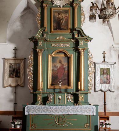 Zdjęcie nr 1: Nastawa architektoniczna, jednoosiowa, dwukondygnacyjna, ustawiona na niewielkim cokole. Ołtarz drewniany, prostopadłościenny, z drewnianą mensą, ustawiony na dwustopniowej podstawie. Antepedium ujęte ramą, w jego polu płycina dekorowana w narożach ornamentem roślinnym, pośrodku medalion z monogramem IHS w glorii promienistej. Na ołtarzu ustawione jest tabernakulum w formie drewnianej skrzynki flankowanej półwalcami oraz falistymi spływami z nałożonymi płaskorzeźbionymi postaciami adorujących puttów. Drzwiczki w kształcie stojącego prostokąta zamkniętego łukiem segmentowym nadwieszonym z kielichem i hostią w polu. 
Pierwsza kondygnacja flankowana jest zwielokrotnionymi pilastrami i stojącą przed nimi parą kolumn o kapitelach kompozytowych, dźwigających pełne belkowanie, z gzymsem dekorowanym kimationem, wyłamane na ich osi, z przerwanym architrawem nad polem środkowym. Na belkowaniu, na osiach kolumn przerwany, falisty przyczółek. W polu środkowym nisza w kształcie stojącego prostokąta zamkniętego łukiem segmentowym nadwieszonym, ujęta profilowaną ramą z obrazem Najświętszego Serca Pana Jezusa w formie stojącego prostokąta w osobnej, profilowanej ramie. Druga kondygnacja ustawiona na niewielkim cokole, flankowana zdwojonymi pilastrami i stojącą przed nimi parą kolumn o kapitelach kompozytowych, dźwigających pełne belkowanie z gzymsem dekorowanym kimationem, wyłamane na ich osi oraz przerwany półkolisty przyczółek. Nad polem, w partii belkowania medalion z przedstawieniem Gorejącego Serca w glorii promienistej, flankowany główkami anielskimi. W polu obraz w kształcie stojącego prostokąta ujętego profilowaną rama z przedstawieniem św. Franciszka obejmującego Chrystusa na krzyżu (amplexus). Obie kondygnacje ujęte uszami, pierwsza utworzonymi ze stylizowanego akantu, druga ze stylizowanego ornamentu roślinnego. Cokoły i belkowanie pierwszej kondygnacji dekorowane stylizowanym ornamentem roślinnym. Struktura ołtarza polichromowana w kolorze jasnozielonym, kolumny i profile pozłocone, ornamentyka pozłocona i posrebrzona. 