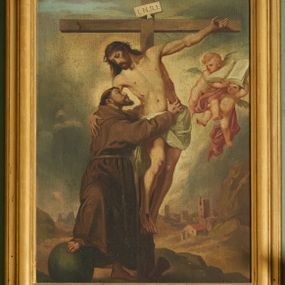 Zdjęcie nr 1: Obraz w formie stojącego prostokąta, przedstawiający św. Franciszka obejmującego Chrystusa na krzyżu. Jezus przybity do krzyża znajdującego się w centrum kompozycji. Ukazany frontalnie, przechylony w prawą stronę, obejmuje ręką św. Franciszka, nogi ma lekko ugięte w kolanach, stopy skrzyżowane w układzie prawa na lewą. Twarz ma pociągłą, z oczami skierowanymi w dół, prostym nosem, okoloną krótką brodą oraz włosami sięgającymi ramion. Na głowie ma koronę cierniową. Ciało szczupłe i umięśnione, z krwawiącymi ranami. Biodra przewiązane krótkim, białym perizonium. Święty Franciszek ukazany w pozycji stojącej, z profilu, z uniesioną głową, prawą nogę wspiera na kuli, obiema rękami obejmuje ciało Chrystusa. Twarz ma szczupłą, z oczami skierowanymi w górę, prostym nosem i pełnymi ustami, okoloną ciemnym zarostem i krótkimi włosami, na głowie tonsura. Ubrany jest w brązowy habit z kapturem, przepasany sznurem. Na dłoniach ma stygmaty. Po lewej stronie Chrystusa nadlatująca para aniołków podtrzymujących otwartą księgę. Scena ukazana na tle pejzażu, z widoczną w oddali panoramą miasta. Niebo szaro-niebieskie, zachmurzone. Obraz ujęty drewnianą, złoconą, profilowaną ramą.