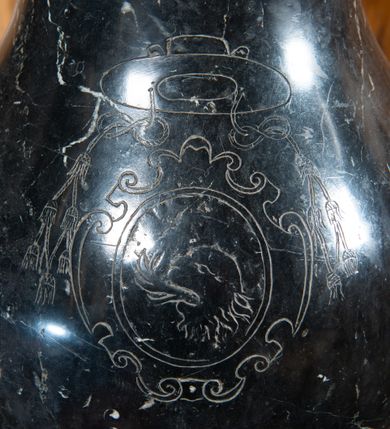 Zdjęcie nr 3: Na niskiej prostopadłościennej podstawie, niewielka stopa z trzonem w typie balustradowej lalki podtrzymującej półkulistą czarę o powierzchni imitującej puklowanie z wklęską i zaoblonym brzegiem. Na trzonie ryty kartusz z godłem herbu Zadora pod kapeluszem z sześcioma chwostami po każdej ze stron, w trzech rzędach. Pokrywa w formie korony zamkniętej, z sześcioma kabłąkami złączonymi kulą i krzyżem; obręcz i kabłąki z malowanymi rautami i kaboszonami imitującymi kamienie jubilerskie. Wewnątrz korony grupa rzeźbiarska: Chrystus w Jordanie, z rękoma w geście modlitwy i św. Jan Chrzciciel polewający wodą głowę Jezusa.  