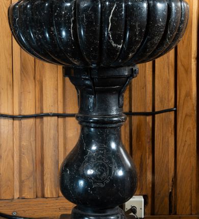 Zdjęcie nr 2: Na niskiej prostopadłościennej podstawie, niewielka stopa z trzonem w typie balustradowej lalki podtrzymującej półkulistą czarę o powierzchni imitującej puklowanie z wklęską i zaoblonym brzegiem. Na trzonie ryty kartusz z godłem herbu Zadora pod kapeluszem z sześcioma chwostami po każdej ze stron, w trzech rzędach. Pokrywa w formie korony zamkniętej, z sześcioma kabłąkami złączonymi kulą i krzyżem; obręcz i kabłąki z malowanymi rautami i kaboszonami imitującymi kamienie jubilerskie. Wewnątrz korony grupa rzeźbiarska: Chrystus w Jordanie, z rękoma w geście modlitwy i św. Jan Chrzciciel polewający wodą głowę Jezusa.  