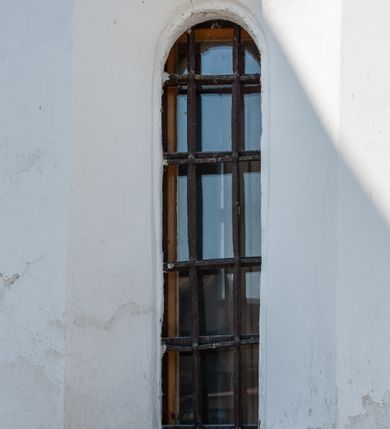 Zdjęcie nr 7: Kościół orientowany, murowany z kamienia, jednonawowy, z prostokątną, trójprzęsłową nawą oraz węższym dwuprzęsłowym prezbiterium zamkniętym trójbocznie, z niewielką prostokątną zakrystią przy północnej ścianie. Od zachodu wieża na planie kwadratu, do północnej ściany nawy dobudowana kaplica Matki Boskiej Karmelitańskiej, do południowej niewielka kruchta. Prezbiterium sklepione żebrowo z jednym rzeźbionym kroksztynem; żebra pokryte późniejszą dekoracją stiukową. Nawa wtórnie sklepiona kolebką z lunetami na gurtach, rozczłonkowana opilastrowanymi półfilarami. Pilastry i zacheuszki ozdobione stiukową ornamentacją. Do zakrystii prowadzi kamienny portal. Kościół opięty grubymi szkarpami jednouskokowymi, nakrytymi daszkami. W dwóch oknach prezbiterium i jednym nawy od południa kamienne maswerki; w zakrystii od wschodu wąskie okienko, tzw. romańskie. W pólnocno-wschodnim narożniku nawy wtórnie wkomponowany rzeźbiony, bardzo zniszczony kroksztyn. Z południowej kruchty do nawy prowadzi kamienny portal o trzech parach kolumienek dźwigających archiwolty. Nawa i prezbiterium nakryte dachem, na ich styku wieżyczka na sygnaturkę. Wieża smukła, bez podziałów architektonicznych, ściany najwyższej kondygnacji cofnięte w głąb, przy krawędzi kamienne kroksztyny, pozostałe po niezachowanej drewnianej hurdycji. Wieża zwieńczona ceglaną attyką, zasłaniającą dwuspadowy dach. W górnej części jej trzonu okna usytuowane z czterech stron. W miejscu hurdycji, na zachodniej ścianie zegar. 

Kościół otoczony niskim murem kamiennym; od zachodu dzwonnica bramna na planie kwadratu z niesklepioną sienią przejściową, nakryta blaszanym hełmem; od południa i od wschodu bramki nakryte hełmami, przy czym jeden pokryty jest gontem, drugi blachą.