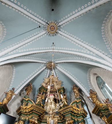 Zdjęcie nr 23: Kościół orientowany, murowany z kamienia, jednonawowy, z prostokątną, trójprzęsłową nawą oraz węższym dwuprzęsłowym prezbiterium zamkniętym trójbocznie, z niewielką prostokątną zakrystią przy północnej ścianie. Od zachodu wieża na planie kwadratu, do północnej ściany nawy dobudowana kaplica Matki Boskiej Karmelitańskiej, do południowej niewielka kruchta. Prezbiterium sklepione żebrowo z jednym rzeźbionym kroksztynem; żebra pokryte późniejszą dekoracją stiukową. Nawa wtórnie sklepiona kolebką z lunetami na gurtach, rozczłonkowana opilastrowanymi półfilarami. Pilastry i zacheuszki ozdobione stiukową ornamentacją. Do zakrystii prowadzi kamienny portal. Kościół opięty grubymi szkarpami jednouskokowymi, nakrytymi daszkami. W dwóch oknach prezbiterium i jednym nawy od południa kamienne maswerki; w zakrystii od wschodu wąskie okienko, tzw. romańskie. W pólnocno-wschodnim narożniku nawy wtórnie wkomponowany rzeźbiony, bardzo zniszczony kroksztyn. Z południowej kruchty do nawy prowadzi kamienny portal o trzech parach kolumienek dźwigających archiwolty. Nawa i prezbiterium nakryte dachem, na ich styku wieżyczka na sygnaturkę. Wieża smukła, bez podziałów architektonicznych, ściany najwyższej kondygnacji cofnięte w głąb, przy krawędzi kamienne kroksztyny, pozostałe po niezachowanej drewnianej hurdycji. Wieża zwieńczona ceglaną attyką, zasłaniającą dwuspadowy dach. W górnej części jej trzonu okna usytuowane z czterech stron. W miejscu hurdycji, na zachodniej ścianie zegar. 

Kościół otoczony niskim murem kamiennym; od zachodu dzwonnica bramna na planie kwadratu z niesklepioną sienią przejściową, nakryta blaszanym hełmem; od południa i od wschodu bramki nakryte hełmami, przy czym jeden pokryty jest gontem, drugi blachą.