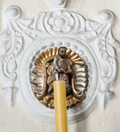 Zdjęcie nr 44: Kościół orientowany, murowany z kamienia, jednonawowy, z prostokątną, trójprzęsłową nawą oraz węższym dwuprzęsłowym prezbiterium zamkniętym trójbocznie, z niewielką prostokątną zakrystią przy północnej ścianie. Od zachodu wieża na planie kwadratu, do północnej ściany nawy dobudowana kaplica Matki Boskiej Karmelitańskiej, do południowej niewielka kruchta. Prezbiterium sklepione żebrowo z jednym rzeźbionym kroksztynem; żebra pokryte późniejszą dekoracją stiukową. Nawa wtórnie sklepiona kolebką z lunetami na gurtach, rozczłonkowana opilastrowanymi półfilarami. Pilastry i zacheuszki ozdobione stiukową ornamentacją. Do zakrystii prowadzi kamienny portal. Kościół opięty grubymi szkarpami jednouskokowymi, nakrytymi daszkami. W dwóch oknach prezbiterium i jednym nawy od południa kamienne maswerki; w zakrystii od wschodu wąskie okienko, tzw. romańskie. W pólnocno-wschodnim narożniku nawy wtórnie wkomponowany rzeźbiony, bardzo zniszczony kroksztyn. Z południowej kruchty do nawy prowadzi kamienny portal o trzech parach kolumienek dźwigających archiwolty. Nawa i prezbiterium nakryte dachem, na ich styku wieżyczka na sygnaturkę. Wieża smukła, bez podziałów architektonicznych, ściany najwyższej kondygnacji cofnięte w głąb, przy krawędzi kamienne kroksztyny, pozostałe po niezachowanej drewnianej hurdycji. Wieża zwieńczona ceglaną attyką, zasłaniającą dwuspadowy dach. W górnej części jej trzonu okna usytuowane z czterech stron. W miejscu hurdycji, na zachodniej ścianie zegar. 

Kościół otoczony niskim murem kamiennym; od zachodu dzwonnica bramna na planie kwadratu z niesklepioną sienią przejściową, nakryta blaszanym hełmem; od południa i od wschodu bramki nakryte hełmami, przy czym jeden pokryty jest gontem, drugi blachą.