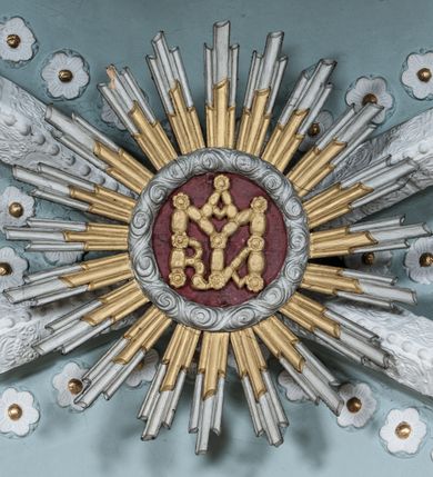 Zdjęcie nr 29: Kościół orientowany, murowany z kamienia, jednonawowy, z prostokątną, trójprzęsłową nawą oraz węższym dwuprzęsłowym prezbiterium zamkniętym trójbocznie, z niewielką prostokątną zakrystią przy północnej ścianie. Od zachodu wieża na planie kwadratu, do północnej ściany nawy dobudowana kaplica Matki Boskiej Karmelitańskiej, do południowej niewielka kruchta. Prezbiterium sklepione żebrowo z jednym rzeźbionym kroksztynem; żebra pokryte późniejszą dekoracją stiukową. Nawa wtórnie sklepiona kolebką z lunetami na gurtach, rozczłonkowana opilastrowanymi półfilarami. Pilastry i zacheuszki ozdobione stiukową ornamentacją. Do zakrystii prowadzi kamienny portal. Kościół opięty grubymi szkarpami jednouskokowymi, nakrytymi daszkami. W dwóch oknach prezbiterium i jednym nawy od południa kamienne maswerki; w zakrystii od wschodu wąskie okienko, tzw. romańskie. W pólnocno-wschodnim narożniku nawy wtórnie wkomponowany rzeźbiony, bardzo zniszczony kroksztyn. Z południowej kruchty do nawy prowadzi kamienny portal o trzech parach kolumienek dźwigających archiwolty. Nawa i prezbiterium nakryte dachem, na ich styku wieżyczka na sygnaturkę. Wieża smukła, bez podziałów architektonicznych, ściany najwyższej kondygnacji cofnięte w głąb, przy krawędzi kamienne kroksztyny, pozostałe po niezachowanej drewnianej hurdycji. Wieża zwieńczona ceglaną attyką, zasłaniającą dwuspadowy dach. W górnej części jej trzonu okna usytuowane z czterech stron. W miejscu hurdycji, na zachodniej ścianie zegar. 

Kościół otoczony niskim murem kamiennym; od zachodu dzwonnica bramna na planie kwadratu z niesklepioną sienią przejściową, nakryta blaszanym hełmem; od południa i od wschodu bramki nakryte hełmami, przy czym jeden pokryty jest gontem, drugi blachą.