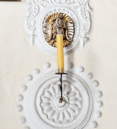 Zdjęcie nr 40: Kościół orientowany, murowany z kamienia, jednonawowy, z prostokątną, trójprzęsłową nawą oraz węższym dwuprzęsłowym prezbiterium zamkniętym trójbocznie, z niewielką prostokątną zakrystią przy północnej ścianie. Od zachodu wieża na planie kwadratu, do północnej ściany nawy dobudowana kaplica Matki Boskiej Karmelitańskiej, do południowej niewielka kruchta. Prezbiterium sklepione żebrowo z jednym rzeźbionym kroksztynem; żebra pokryte późniejszą dekoracją stiukową. Nawa wtórnie sklepiona kolebką z lunetami na gurtach, rozczłonkowana opilastrowanymi półfilarami. Pilastry i zacheuszki ozdobione stiukową ornamentacją. Do zakrystii prowadzi kamienny portal. Kościół opięty grubymi szkarpami jednouskokowymi, nakrytymi daszkami. W dwóch oknach prezbiterium i jednym nawy od południa kamienne maswerki; w zakrystii od wschodu wąskie okienko, tzw. romańskie. W pólnocno-wschodnim narożniku nawy wtórnie wkomponowany rzeźbiony, bardzo zniszczony kroksztyn. Z południowej kruchty do nawy prowadzi kamienny portal o trzech parach kolumienek dźwigających archiwolty. Nawa i prezbiterium nakryte dachem, na ich styku wieżyczka na sygnaturkę. Wieża smukła, bez podziałów architektonicznych, ściany najwyższej kondygnacji cofnięte w głąb, przy krawędzi kamienne kroksztyny, pozostałe po niezachowanej drewnianej hurdycji. Wieża zwieńczona ceglaną attyką, zasłaniającą dwuspadowy dach. W górnej części jej trzonu okna usytuowane z czterech stron. W miejscu hurdycji, na zachodniej ścianie zegar. 

Kościół otoczony niskim murem kamiennym; od zachodu dzwonnica bramna na planie kwadratu z niesklepioną sienią przejściową, nakryta blaszanym hełmem; od południa i od wschodu bramki nakryte hełmami, przy czym jeden pokryty jest gontem, drugi blachą.