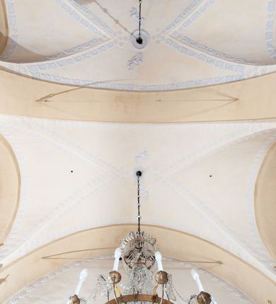 Zdjęcie nr 33: Kościół orientowany, murowany z kamienia, jednonawowy, z prostokątną, trójprzęsłową nawą oraz węższym dwuprzęsłowym prezbiterium zamkniętym trójbocznie, z niewielką prostokątną zakrystią przy północnej ścianie. Od zachodu wieża na planie kwadratu, do północnej ściany nawy dobudowana kaplica Matki Boskiej Karmelitańskiej, do południowej niewielka kruchta. Prezbiterium sklepione żebrowo z jednym rzeźbionym kroksztynem; żebra pokryte późniejszą dekoracją stiukową. Nawa wtórnie sklepiona kolebką z lunetami na gurtach, rozczłonkowana opilastrowanymi półfilarami. Pilastry i zacheuszki ozdobione stiukową ornamentacją. Do zakrystii prowadzi kamienny portal. Kościół opięty grubymi szkarpami jednouskokowymi, nakrytymi daszkami. W dwóch oknach prezbiterium i jednym nawy od południa kamienne maswerki; w zakrystii od wschodu wąskie okienko, tzw. romańskie. W pólnocno-wschodnim narożniku nawy wtórnie wkomponowany rzeźbiony, bardzo zniszczony kroksztyn. Z południowej kruchty do nawy prowadzi kamienny portal o trzech parach kolumienek dźwigających archiwolty. Nawa i prezbiterium nakryte dachem, na ich styku wieżyczka na sygnaturkę. Wieża smukła, bez podziałów architektonicznych, ściany najwyższej kondygnacji cofnięte w głąb, przy krawędzi kamienne kroksztyny, pozostałe po niezachowanej drewnianej hurdycji. Wieża zwieńczona ceglaną attyką, zasłaniającą dwuspadowy dach. W górnej części jej trzonu okna usytuowane z czterech stron. W miejscu hurdycji, na zachodniej ścianie zegar. 

Kościół otoczony niskim murem kamiennym; od zachodu dzwonnica bramna na planie kwadratu z niesklepioną sienią przejściową, nakryta blaszanym hełmem; od południa i od wschodu bramki nakryte hełmami, przy czym jeden pokryty jest gontem, drugi blachą.