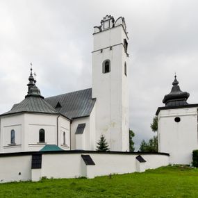 Zdjęcie nr 1: Kościół orientowany, murowany z kamienia, jednonawowy, z prostokątną, trójprzęsłową nawą oraz węższym dwuprzęsłowym prezbiterium zamkniętym trójbocznie, z niewielką prostokątną zakrystią przy północnej ścianie. Od zachodu wieża na planie kwadratu, do północnej ściany nawy dobudowana kaplica Matki Boskiej Karmelitańskiej, do południowej niewielka kruchta. Prezbiterium sklepione żebrowo z jednym rzeźbionym kroksztynem; żebra pokryte późniejszą dekoracją stiukową. Nawa wtórnie sklepiona kolebką z lunetami na gurtach, rozczłonkowana opilastrowanymi półfilarami. Pilastry i zacheuszki ozdobione stiukową ornamentacją. Do zakrystii prowadzi kamienny portal. Kościół opięty grubymi szkarpami jednouskokowymi, nakrytymi daszkami. W dwóch oknach prezbiterium i jednym nawy od południa kamienne maswerki; w zakrystii od wschodu wąskie okienko, tzw. romańskie. W pólnocno-wschodnim narożniku nawy wtórnie wkomponowany rzeźbiony, bardzo zniszczony kroksztyn. Z południowej kruchty do nawy prowadzi kamienny portal o trzech parach kolumienek dźwigających archiwolty. Nawa i prezbiterium nakryte dachem, na ich styku wieżyczka na sygnaturkę. Wieża smukła, bez podziałów architektonicznych, ściany najwyższej kondygnacji cofnięte w głąb, przy krawędzi kamienne kroksztyny, pozostałe po niezachowanej drewnianej hurdycji. Wieża zwieńczona ceglaną attyką, zasłaniającą dwuspadowy dach. W górnej części jej trzonu okna usytuowane z czterech stron. W miejscu hurdycji, na zachodniej ścianie zegar. 

Kościół otoczony niskim murem kamiennym; od zachodu dzwonnica bramna na planie kwadratu z niesklepioną sienią przejściową, nakryta blaszanym hełmem; od południa i od wschodu bramki nakryte hełmami, przy czym jeden pokryty jest gontem, drugi blachą.