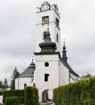 Zdjęcie nr 2: Kościół orientowany, murowany z kamienia, jednonawowy, z prostokątną, trójprzęsłową nawą oraz węższym dwuprzęsłowym prezbiterium zamkniętym trójbocznie, z niewielką prostokątną zakrystią przy północnej ścianie. Od zachodu wieża na planie kwadratu, do północnej ściany nawy dobudowana kaplica Matki Boskiej Karmelitańskiej, do południowej niewielka kruchta. Prezbiterium sklepione żebrowo z jednym rzeźbionym kroksztynem; żebra pokryte późniejszą dekoracją stiukową. Nawa wtórnie sklepiona kolebką z lunetami na gurtach, rozczłonkowana opilastrowanymi półfilarami. Pilastry i zacheuszki ozdobione stiukową ornamentacją. Do zakrystii prowadzi kamienny portal. Kościół opięty grubymi szkarpami jednouskokowymi, nakrytymi daszkami. W dwóch oknach prezbiterium i jednym nawy od południa kamienne maswerki; w zakrystii od wschodu wąskie okienko, tzw. romańskie. W pólnocno-wschodnim narożniku nawy wtórnie wkomponowany rzeźbiony, bardzo zniszczony kroksztyn. Z południowej kruchty do nawy prowadzi kamienny portal o trzech parach kolumienek dźwigających archiwolty. Nawa i prezbiterium nakryte dachem, na ich styku wieżyczka na sygnaturkę. Wieża smukła, bez podziałów architektonicznych, ściany najwyższej kondygnacji cofnięte w głąb, przy krawędzi kamienne kroksztyny, pozostałe po niezachowanej drewnianej hurdycji. Wieża zwieńczona ceglaną attyką, zasłaniającą dwuspadowy dach. W górnej części jej trzonu okna usytuowane z czterech stron. W miejscu hurdycji, na zachodniej ścianie zegar. 

Kościół otoczony niskim murem kamiennym; od zachodu dzwonnica bramna na planie kwadratu z niesklepioną sienią przejściową, nakryta blaszanym hełmem; od południa i od wschodu bramki nakryte hełmami, przy czym jeden pokryty jest gontem, drugi blachą.