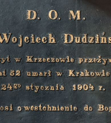 Zdjęcie nr 1: Epitafium w formie tablicy w kształcie leżącego prostokąta, ujętej profilowaną, złoconą ramą. Na czarnym tle złocony napis 
„D(EO) O(PTIMO) M(AXIMO) / X(iądz) Wojciech Dudziński / Expozyt w Krzeczowie przeżywszy / lat 52 umarł w Krakowie / 24go stycznia 1904 r(oku) / Prosi o westchnienie do Boga."