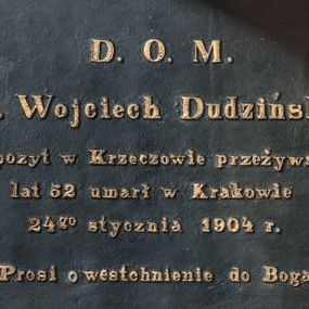 Zdjęcie nr 1: Epitafium w formie tablicy w kształcie leżącego prostokąta, ujętej profilowaną, złoconą ramą. Na czarnym tle złocony napis 
„D(EO) O(PTIMO) M(AXIMO) / X(iądz) Wojciech Dudziński / Expozyt w Krzeczowie przeżywszy / lat 52 umarł w Krakowie / 24go stycznia 1904 r(oku) / Prosi o westchnienie do Boga.&quot;