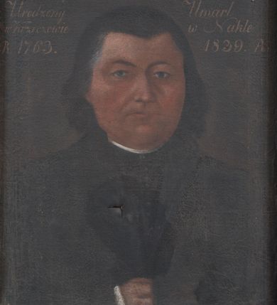 Zdjęcie nr 1: Obraz w kształcie stojącego prostokąta z półpostaciowym portretem księdza Józefa Mastelskiego. Mężczyzna, ukazany na jednolitym, ciemnobrązowym tle, zwrócony jest nieznacznie  w lewą stronę. Pełną, o owalnym obrysie twarz charakteryzują surowe, sumarycznie modelowane rysy dojrzałego mężczyzny o niebieskich, lekko ukośnych oczach, niewielkim nosie i wąskich ustach. Ciemne włosy zaczesane są do tyłu. Postać ubrana jest w sutannę i czarny płaszcz, wokół szyi koloratka. U dołu kompozycji fragmentarycznie widoczna jest wsunięta za połę płaszcza prawa dłoń. 
 U góry obrazu napis „X(iądz) Józef Mastelski Kanonik i Proboszcz / Urodzony / w Krzeczowie / R(oku)1763. / Umarł / w Nakle / 1839. R(oku)”.

 Napis na odwrocie „Reverendus Josephus / Mastelski / Natus 1763. / Ordinatus 1786. / Expictus 1800. / Mortuus 1839. / in Naklo parochus”.

