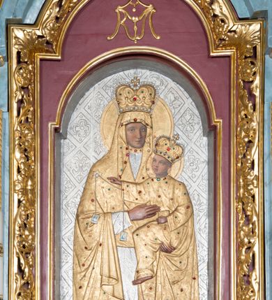 Zdjęcie nr 15: Ołtarz przyścienny, architektoniczny, jednokondygnacyjny ze zwieńczeniem i bramkami. 
Ołtarz prostopadłościenny z mensą wspartą na dwóch tralkach. Antepedium ujęte parą tralek.
Retabulum z uszakami flankowane parą kolumn korynckich o skręcanych trzonach, ustawionych na niskich wysuniętych cokołach. Podpory wspierają odcinki wyłamanego belkowania z architrawem wygiętym w łuk półkolisty. Powyżej belkowania ustawione odcinki wklęsłego przyczółka. 
Zwieńczenie prostopadłościenne z uszakami, zamknięte łukiem nadwieszanym wspieranym przez parę podwójnych pilastrów.
Po bokach ołtarza bramki o wklęsło-wypukłym wykroju z otworami drzwiowymi w kształcie stojącego prostokąta z ćwierćkoliście wklęsłymi górnymi narożami. 
Pole środkowe retabulum w formie wnęki w kształcie prostokąta zamkniętej łukiem nadwieszanym, ujętej podwójnym obramieniem o analogicznym wykroju. We wnęce obraz z przedstawieniem Matki Boskiej z Dzieciątkiem. W antepedium obraz w kształcie leżącego prostokąta z przedstawieniem kielicha z hostią adorowanego przez św. Wojciecha i nieznanego świętego. W zwieńczeniu obraz w kształcie stojącego prostokąta z przedstawieniem Trójcy Świętej ujęty profilowaną ramą.
Nad bramkami, ustawione na cokołach figury św. Wojciecha po prawej oraz św. Stanisława po lewej stronie. Na odcinkach przyczółka ukazane całopostaciowe figury uskrzydlonych aniołków. 
Uszaki ołtarza ażurowe, formowane ze skręconych liści akantu z kwiatami. Wnęka pola środkowego retabulum ujęta szeroką, ażurową ramą formowaną z liści akantu i kwiatów. Poniżej aplikowany monogram maryjny. Po bokach wnęki ornament cekinowy. Poniżej gzymsu ażurowy ornament akantowy. Trzony kolumn oplecione płaskorzeźbioną wicią winorośli. Ścianki cokołów dekorowane płycinami z rzeźbionym liściem akantu. W zwieńczeniu aplikowany rzeźbiony monogram maryjny ujęty wieńcem z koroną. 
Całość struktury ołtarza malowana na jasnobłękitny odcień z marmoryzacją w odcieniach szarości. Profilowania, ornamenty i detal architektoniczny pozłacane.
