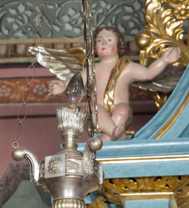 Zdjęcie nr 4: Ołtarz przyścienny, architektoniczny, jednokondygnacyjny ze zwieńczeniem i bramkami. 
Ołtarz prostopadłościenny z mensą wspartą na dwóch tralkach. Antepedium ujęte parą tralek.
Retabulum z uszakami flankowane parą kolumn korynckich o skręcanych trzonach, ustawionych na niskich wysuniętych cokołach. Podpory wspierają odcinki wyłamanego belkowania z architrawem wygiętym w łuk półkolisty. Powyżej belkowania ustawione odcinki wklęsłego przyczółka. 
Zwieńczenie prostopadłościenne z uszakami, zamknięte łukiem nadwieszanym wspieranym przez parę podwójnych pilastrów.
Po bokach ołtarza bramki o wklęsło-wypukłym wykroju z otworami drzwiowymi w kształcie stojącego prostokąta z ćwierćkoliście wklęsłymi górnymi narożami. 
Pole środkowe retabulum w formie wnęki w kształcie prostokąta zamkniętej łukiem nadwieszanym, ujętej podwójnym obramieniem o analogicznym wykroju. We wnęce obraz z przedstawieniem Matki Boskiej z Dzieciątkiem. W antepedium obraz w kształcie leżącego prostokąta z przedstawieniem kielicha z hostią adorowanego przez św. Wojciecha i nieznanego świętego. W zwieńczeniu obraz w kształcie stojącego prostokąta z przedstawieniem Trójcy Świętej ujęty profilowaną ramą.
Nad bramkami, ustawione na cokołach figury św. Wojciecha po prawej oraz św. Stanisława po lewej stronie. Na odcinkach przyczółka ukazane całopostaciowe figury uskrzydlonych aniołków. 
Uszaki ołtarza ażurowe, formowane ze skręconych liści akantu z kwiatami. Wnęka pola środkowego retabulum ujęta szeroką, ażurową ramą formowaną z liści akantu i kwiatów. Poniżej aplikowany monogram maryjny. Po bokach wnęki ornament cekinowy. Poniżej gzymsu ażurowy ornament akantowy. Trzony kolumn oplecione płaskorzeźbioną wicią winorośli. Ścianki cokołów dekorowane płycinami z rzeźbionym liściem akantu. W zwieńczeniu aplikowany rzeźbiony monogram maryjny ujęty wieńcem z koroną. 
Całość struktury ołtarza malowana na jasnobłękitny odcień z marmoryzacją w odcieniach szarości. Profilowania, ornamenty i detal architektoniczny pozłacane.
