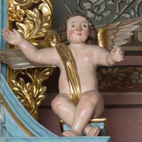 Zdjęcie nr 1: Pełnoplastyczne figury uskrzydlonych aniołków ustawionych przeciwstawnie. Postaci zostały ukazane w pozycji siedzącej, z uniesionymi wysoko rękoma i skrzyżowanymi nogami. Biodra osłonięte wąską, złota szarfą przerzuconą przez ramię. Twarze owalne, pełne, okolone puklami brązowych włosów. Karnacje ciała w naturalnym, jasnokremowym odcieniu, policzki zaróżowione.