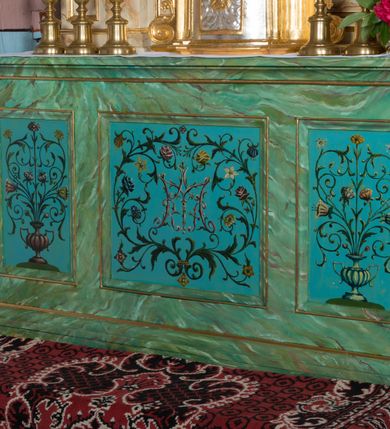 Zdjęcie nr 11: Ołtarz architektoniczny, jednokondygnacyjny, jednoosiowy ze zwieńczeniem. Ołtarz jest prostopadłościenny, z drewnianą mensą. Retabulum osadzone jest na niewysokim, zryzalitowanym cokole. Część środkową nastawy ujmuje para kolumn o korynckich kapitelach, ustawionych na tle zdwojonych pilastrów. Podpory wspierają wyłamujące się ponad nimi belkowanie przerwane w partii architrawu i fryzu. Część środkowa zaaranżowana jest w formie trójbocznej niszy o wykroju zamkniętym łukiem półkolistym, ujętej prostokątną płyciną. Zamknięte trójkątnie zwieńczenie ujęte jest parą pilastrów wspierających gzyms wieńczący. Dodatkowo po bokach znajduje się para niewysokich cokolików oraz przerwany, wklęsły przyczółek. Środkowa płycina antepedium zdobiona jest polichromowanym monogramem maryjnym, ujętym wieńcem kwiatów, płyciny po bokach zdobią wazony z kwiatami. W partii fryzu retabulum oraz na kapitelach pilastrów w zwieńczeniu są motywy rozet. Szczyt zwieńczenia jest w formie ażurowego ornamentu stylizowanej wici roślinnej, po bokach para płomienistych wazonów. W niszy części środkowej retabulum jest figura św. Józefa, w zwieńczeniu obraz w kształcie stojącego prostokąta o ściętych górnych narożach z wizerunkiem św. Antoniego Padewskiego. Na cokolikach ujmujących zwieńczenie usytuowana jest para figur siedzących aniołków.

Struktura ołtarza jest marmoryzowana w odcieniach kremu, beżów i zieleni, detal architektoniczny oraz ornamentyka są złocone.      
