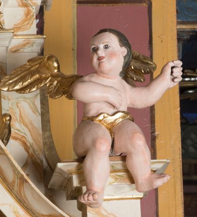 Zdjęcie nr 9: Ołtarz architektoniczny, jednokondygnacyjny, jednoosiowy ze zwieńczeniem. Ołtarz jest prostopadłościenny, z drewnianą mensą. Retabulum osadzone jest na niewysokim, zryzalitowanym cokole. Część środkową nastawy ujmuje para kolumn o korynckich kapitelach, ustawionych na tle zdwojonych pilastrów. Podpory wspierają wyłamujące się ponad nimi belkowanie przerwane w partii architrawu i fryzu. Część środkowa zaaranżowana jest w formie trójbocznej niszy o wykroju zamkniętym łukiem półkolistym, ujętej prostokątną płyciną. Zamknięte trójkątnie zwieńczenie ujęte jest parą pilastrów wspierających gzyms wieńczący. Dodatkowo po bokach znajduje się para niewysokich cokolików oraz przerwany, wklęsły przyczółek. Środkowa płycina antepedium zdobiona jest polichromowanym monogramem maryjnym, ujętym wieńcem kwiatów, płyciny po bokach zdobią wazony z kwiatami. W partii fryzu retabulum oraz na kapitelach pilastrów w zwieńczeniu są motywy rozet. Szczyt zwieńczenia jest w formie ażurowego ornamentu stylizowanej wici roślinnej, po bokach para płomienistych wazonów. W niszy części środkowej retabulum jest figura św. Józefa, w zwieńczeniu obraz w kształcie stojącego prostokąta o ściętych górnych narożach z wizerunkiem św. Antoniego Padewskiego. Na cokolikach ujmujących zwieńczenie usytuowana jest para figur siedzących aniołków.

Struktura ołtarza jest marmoryzowana w odcieniach kremu, beżów i zieleni, detal architektoniczny oraz ornamentyka są złocone.      
