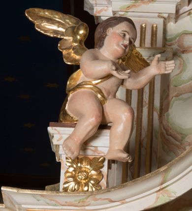 Zdjęcie nr 5: Ołtarz architektoniczny, jednokondygnacyjny, jednoosiowy ze zwieńczeniem. Ołtarz jest prostopadłościenny, z drewnianą mensą. Retabulum osadzone jest na niewysokim, zryzalitowanym cokole. Część środkową nastawy ujmuje para kolumn o korynckich kapitelach, ustawionych na tle zdwojonych pilastrów. Podpory wspierają wyłamujące się ponad nimi belkowanie przerwane w partii architrawu i fryzu. Część środkowa zaaranżowana jest w formie trójbocznej niszy o wykroju zamkniętym łukiem półkolistym, ujętej prostokątną płyciną. Zamknięte trójkątnie zwieńczenie ujęte jest parą pilastrów wspierających gzyms wieńczący. Dodatkowo po bokach znajduje się para niewysokich cokolików oraz przerwany, wklęsły przyczółek o fantazyjnym wykroju. Środkowa płycina antepedium zdobiona jest polichromowanym monogramem chrystologicznym, płyciny po bokach różanymi krzewami. W partii fryzu retabulum oraz na cokolikach w zwieńczeniu są motywy rozet. Szczyt zwieńczenia jest w formie ażurowego ornamentu stylizowanej wici roślinnej, po bokach para płomienistych wazonów. W niszy części środkowej retabulum jest figura Najświętszego Serca Jezusa, w zwieńczeniu obraz w kształcie stojącego prostokąta zamkniętego nadwieszonym łukiem odcinkowym, ujęty profilowaną, złoconą ramą, zawiera wizerunek św. Małgorzaty. Na cokolikach ujmujących zwieńczenie usytuowana jest para figur siedzących aniołków.

Struktura ołtarza jest marmoryzowana w odcieniach kremu, beżów i zieleni, detal architektoniczny oraz ornamentyka są złocone.      
