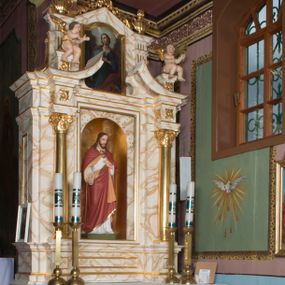 Zdjęcie nr 1: Ołtarz architektoniczny, jednokondygnacyjny, jednoosiowy ze zwieńczeniem. Ołtarz jest prostopadłościenny, z drewnianą mensą. Retabulum osadzone jest na niewysokim, zryzalitowanym cokole. Część środkową nastawy ujmuje para kolumn o korynckich kapitelach, ustawionych na tle zdwojonych pilastrów. Podpory wspierają wyłamujące się ponad nimi belkowanie przerwane w partii architrawu i fryzu. Część środkowa zaaranżowana jest w formie trójbocznej niszy o wykroju zamkniętym łukiem półkolistym, ujętej prostokątną płyciną. Zamknięte trójkątnie zwieńczenie ujęte jest parą pilastrów wspierających gzyms wieńczący. Dodatkowo po bokach znajduje się para niewysokich cokolików oraz przerwany, wklęsły przyczółek o fantazyjnym wykroju. Środkowa płycina antepedium zdobiona jest polichromowanym monogramem chrystologicznym, płyciny po bokach różanymi krzewami. W partii fryzu retabulum oraz na cokolikach w zwieńczeniu są motywy rozet. Szczyt zwieńczenia jest w formie ażurowego ornamentu stylizowanej wici roślinnej, po bokach para płomienistych wazonów. W niszy części środkowej retabulum jest figura Najświętszego Serca Jezusa, w zwieńczeniu obraz w kształcie stojącego prostokąta zamkniętego nadwieszonym łukiem odcinkowym, ujęty profilowaną, złoconą ramą, zawiera wizerunek św. Małgorzaty. Na cokolikach ujmujących zwieńczenie usytuowana jest para figur siedzących aniołków.

Struktura ołtarza jest marmoryzowana w odcieniach kremu, beżów i zieleni, detal architektoniczny oraz ornamentyka są złocone.      
