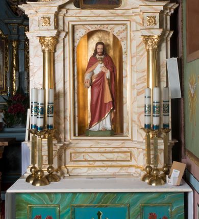 Zdjęcie nr 3: Ołtarz architektoniczny, jednokondygnacyjny, jednoosiowy ze zwieńczeniem. Ołtarz jest prostopadłościenny, z drewnianą mensą. Retabulum osadzone jest na niewysokim, zryzalitowanym cokole. Część środkową nastawy ujmuje para kolumn o korynckich kapitelach, ustawionych na tle zdwojonych pilastrów. Podpory wspierają wyłamujące się ponad nimi belkowanie przerwane w partii architrawu i fryzu. Część środkowa zaaranżowana jest w formie trójbocznej niszy o wykroju zamkniętym łukiem półkolistym, ujętej prostokątną płyciną. Zamknięte trójkątnie zwieńczenie ujęte jest parą pilastrów wspierających gzyms wieńczący. Dodatkowo po bokach znajduje się para niewysokich cokolików oraz przerwany, wklęsły przyczółek o fantazyjnym wykroju. Środkowa płycina antepedium zdobiona jest polichromowanym monogramem chrystologicznym, płyciny po bokach różanymi krzewami. W partii fryzu retabulum oraz na cokolikach w zwieńczeniu są motywy rozet. Szczyt zwieńczenia jest w formie ażurowego ornamentu stylizowanej wici roślinnej, po bokach para płomienistych wazonów. W niszy części środkowej retabulum jest figura Najświętszego Serca Jezusa, w zwieńczeniu obraz w kształcie stojącego prostokąta zamkniętego nadwieszonym łukiem odcinkowym, ujęty profilowaną, złoconą ramą, zawiera wizerunek św. Małgorzaty. Na cokolikach ujmujących zwieńczenie usytuowana jest para figur siedzących aniołków.

Struktura ołtarza jest marmoryzowana w odcieniach kremu, beżów i zieleni, detal architektoniczny oraz ornamentyka są złocone.      
