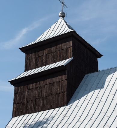Zdjęcie nr 22: Kościół drewniany o konstrukcji zrębowej, elewacje jednolite, szalowane gontem. Wieża i kruchta zachodnia o konstrukcji słupowo-ramowej, narożne słupy nośne wzmocnione krzyżami św. Andrzeja. Więźba dachowa drewniana, krokwiowa. Budynek na kamiennym podmurowaniu. 
Kościół orientowany, jednonawowy, nawa na rzucie prostokąta zbliżonego do kwadratu, prezbiterium nieco węższe, wydłużone, zakończone trójbocznie. Do północnej ściany prezbiterium przylega zakrystia na planie prostokąta. Przy zachodniej ścianie nawy wieża na planie zbliżonym do prostokąta, o lekko ukośnej ścianie południowej. Od zachodu do wieży przylega kruchta na rzucie prostokąta. 
W przyziemiu wieży babiniec połączony z nawą wtórnym otworem w ścianie. Pomiędzy nawą a prezbiterium otwór tęczowy. Parapet chóru muzycznego w zachodniej części nawy, wsparty na czterech drewnianych kolumnach, z wejściem z nawy po drabiniastych schodach. Ściany i sklepienia pokryte polichromią z iluzjonistyczną architekturą i scenami figuralnymi. Wnętrze nakryte pułapami deskowymi w nawie i prezbiterium oraz stropem belkowym w babińcu. Otwory drzwiowe o prostokątnym wykroju zamknięte drzwiami obitymi deskami w kruchcie zachodniej, w ścianie południowej nawy oraz z prezbiterium do zakrystii. Okna w formie stojącego prostokąta. Posadzka kamienna, z płyt marmurowych. 
Elewacja frontowa jednoosiowa. Na osi wejście do kruchty zachodniej. Korpus wieży podzielony poziomo daszkami okapowymi, na froncie okno. Elewacje boczne jednolite. Korpus nawowy przepruty oknami po dwa na ścianach północnej i południowej, prezbiterium z oknem na ścianie południowej oraz dwoma okienkami na ścianach zamknięcia. Na elewacji wschodniej zawieszony krucyfiks. 
Kościół nakryty dachami dwuspadowymi, o pokryciu blaszanym, wyższym nad nawą, niższym nad prezbiterium. W połowie długości dachu, nad nawą, wbudowana wieżyczka na sygnaturkę, na ośmiobocznym, obitym blachą trzonie, z latarnią zwieńczoną niewielkim hełmem. Wieża nakryta czterospadowym daszkiem namiotowym, zwieńczona kulistą puszką i krzyżem. Kruchta nakryta osobnym daszkiem dwuspadowym, półszczytowym, zakrystia niższym dachem pulpitowym.
