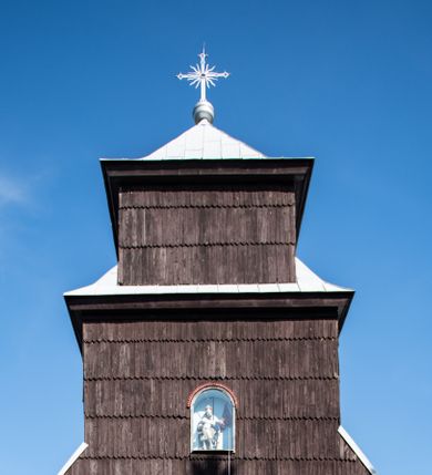 Zdjęcie nr 6: Kościół drewniany o konstrukcji zrębowej, elewacje jednolite, szalowane gontem. Wieża i kruchta zachodnia o konstrukcji słupowo-ramowej, narożne słupy nośne wzmocnione krzyżami św. Andrzeja. Więźba dachowa drewniana, krokwiowa. Budynek na kamiennym podmurowaniu. 
Kościół orientowany, jednonawowy, nawa na rzucie prostokąta zbliżonego do kwadratu, prezbiterium nieco węższe, wydłużone, zakończone trójbocznie. Do północnej ściany prezbiterium przylega zakrystia na planie prostokąta. Przy zachodniej ścianie nawy wieża na planie zbliżonym do prostokąta, o lekko ukośnej ścianie południowej. Od zachodu do wieży przylega kruchta na rzucie prostokąta. 
W przyziemiu wieży babiniec połączony z nawą wtórnym otworem w ścianie. Pomiędzy nawą a prezbiterium otwór tęczowy. Parapet chóru muzycznego w zachodniej części nawy, wsparty na czterech drewnianych kolumnach, z wejściem z nawy po drabiniastych schodach. Ściany i sklepienia pokryte polichromią z iluzjonistyczną architekturą i scenami figuralnymi. Wnętrze nakryte pułapami deskowymi w nawie i prezbiterium oraz stropem belkowym w babińcu. Otwory drzwiowe o prostokątnym wykroju zamknięte drzwiami obitymi deskami w kruchcie zachodniej, w ścianie południowej nawy oraz z prezbiterium do zakrystii. Okna w formie stojącego prostokąta. Posadzka kamienna, z płyt marmurowych. 
Elewacja frontowa jednoosiowa. Na osi wejście do kruchty zachodniej. Korpus wieży podzielony poziomo daszkami okapowymi, na froncie okno. Elewacje boczne jednolite. Korpus nawowy przepruty oknami po dwa na ścianach północnej i południowej, prezbiterium z oknem na ścianie południowej oraz dwoma okienkami na ścianach zamknięcia. Na elewacji wschodniej zawieszony krucyfiks. 
Kościół nakryty dachami dwuspadowymi, o pokryciu blaszanym, wyższym nad nawą, niższym nad prezbiterium. W połowie długości dachu, nad nawą, wbudowana wieżyczka na sygnaturkę, na ośmiobocznym, obitym blachą trzonie, z latarnią zwieńczoną niewielkim hełmem. Wieża nakryta czterospadowym daszkiem namiotowym, zwieńczona kulistą puszką i krzyżem. Kruchta nakryta osobnym daszkiem dwuspadowym, półszczytowym, zakrystia niższym dachem pulpitowym.
