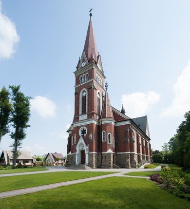 Zdjęcie nr 2: Kościół orientowany, składający się trójnawowej, czteroprzęsłowej pseudohali z transeptem oraz z jednoprzęsłowym, zamkniętym trójbocznie prezbiterium, przy którym od północy usytuowana jest zakrystia, a od południa skarbiec, zamknięte dwubocznie. Od fasady, na przedłużeniu nawy, usytuowana jest czteroboczna wieża, a przy niej ośmioboczne wieżyczki schodowe. Kościół ustawiony jest na wysokim, kamiennym cokole. Wieża trójkondygnacyjna: w dolnej kondygnacji ostrołukowy portal w obramieniu z kolumienkami i wimpergą, nad nim rozeta; w drugiej, ostrołukowe okno z maswerkiem; w trzeciej tryforium. Ściany wieży są zwieńczone szczytami, a wieżyczki schodowe ostrosłupowymi ceglanymi hełmami. Elewacje opięte są przyporami, zwieńczone gzymsem. Okna ostrołukowe z maswerkami, w tynkowanych na biało obramieniach. Dachy dwuspadowe, nad zakrystią i skarbcem pulpitowe, hełm wieży ostrosłupowy; pokrycie blachą. Empora organowa znajduje się w zachodnim przęśle nawy. Sklepienia krzyżowo-żebrowe, przy prezbiterium – gwiaździste. Nawy oddzielone kolumnami o kapitelach pączkowych; na ścianach naw bocznych pilastry. Chór muzyczny na kolumnach z kapitelami kostkowymi. Okna prostokątne zakończone ostrołukowo, w prezbiterium: jednodzielne, usytuowane w trzech ścianach zamknięcia chóru, z witrażami; w korpusie nawowym: trój- i dwudzielne, w pierwszych (wschodnich) trzech przęsłach z witrażami. Żebra sklepienne podkreślone polichromią. Portal główny zdobi tondo z płaskorzeźbą Najświętszego Serca Pana Jezusa.