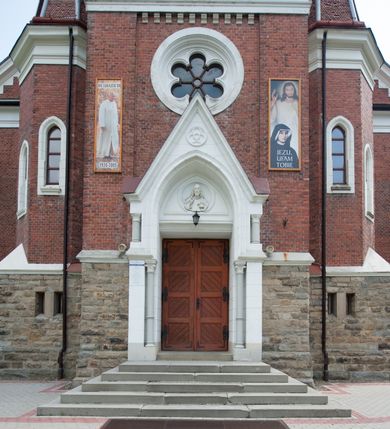 Zdjęcie nr 14: Kościół orientowany, składający się trójnawowej, czteroprzęsłowej pseudohali z transeptem oraz z jednoprzęsłowym, zamkniętym trójbocznie prezbiterium, przy którym od północy usytuowana jest zakrystia, a od południa skarbiec, zamknięte dwubocznie. Od fasady, na przedłużeniu nawy, usytuowana jest czteroboczna wieża, a przy niej ośmioboczne wieżyczki schodowe. Kościół ustawiony jest na wysokim, kamiennym cokole. Wieża trójkondygnacyjna: w dolnej kondygnacji ostrołukowy portal w obramieniu z kolumienkami i wimpergą, nad nim rozeta; w drugiej, ostrołukowe okno z maswerkiem; w trzeciej tryforium. Ściany wieży są zwieńczone szczytami, a wieżyczki schodowe ostrosłupowymi ceglanymi hełmami. Elewacje opięte są przyporami, zwieńczone gzymsem. Okna ostrołukowe z maswerkami, w tynkowanych na biało obramieniach. Dachy dwuspadowe, nad zakrystią i skarbcem pulpitowe, hełm wieży ostrosłupowy; pokrycie blachą. Empora organowa znajduje się w zachodnim przęśle nawy. Sklepienia krzyżowo-żebrowe, przy prezbiterium – gwiaździste. Nawy oddzielone kolumnami o kapitelach pączkowych; na ścianach naw bocznych pilastry. Chór muzyczny na kolumnach z kapitelami kostkowymi. Okna prostokątne zakończone ostrołukowo, w prezbiterium: jednodzielne, usytuowane w trzech ścianach zamknięcia chóru, z witrażami; w korpusie nawowym: trój- i dwudzielne, w pierwszych (wschodnich) trzech przęsłach z witrażami. Żebra sklepienne podkreślone polichromią. Portal główny zdobi tondo z płaskorzeźbą Najświętszego Serca Pana Jezusa.