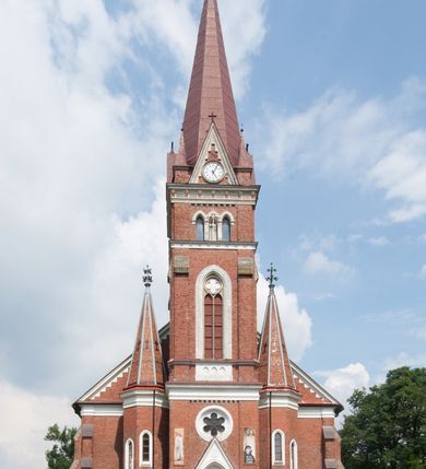 Zdjęcie nr 8: Kościół orientowany, składający się trójnawowej, czteroprzęsłowej pseudohali z transeptem oraz z jednoprzęsłowym, zamkniętym trójbocznie prezbiterium, przy którym od północy usytuowana jest zakrystia, a od południa skarbiec, zamknięte dwubocznie. Od fasady, na przedłużeniu nawy, usytuowana jest czteroboczna wieża, a przy niej ośmioboczne wieżyczki schodowe. Kościół ustawiony jest na wysokim, kamiennym cokole. Wieża trójkondygnacyjna: w dolnej kondygnacji ostrołukowy portal w obramieniu z kolumienkami i wimpergą, nad nim rozeta; w drugiej, ostrołukowe okno z maswerkiem; w trzeciej tryforium. Ściany wieży są zwieńczone szczytami, a wieżyczki schodowe ostrosłupowymi ceglanymi hełmami. Elewacje opięte są przyporami, zwieńczone gzymsem. Okna ostrołukowe z maswerkami, w tynkowanych na biało obramieniach. Dachy dwuspadowe, nad zakrystią i skarbcem pulpitowe, hełm wieży ostrosłupowy; pokrycie blachą. Empora organowa znajduje się w zachodnim przęśle nawy. Sklepienia krzyżowo-żebrowe, przy prezbiterium – gwiaździste. Nawy oddzielone kolumnami o kapitelach pączkowych; na ścianach naw bocznych pilastry. Chór muzyczny na kolumnach z kapitelami kostkowymi. Okna prostokątne zakończone ostrołukowo, w prezbiterium: jednodzielne, usytuowane w trzech ścianach zamknięcia chóru, z witrażami; w korpusie nawowym: trój- i dwudzielne, w pierwszych (wschodnich) trzech przęsłach z witrażami. Żebra sklepienne podkreślone polichromią. Portal główny zdobi tondo z płaskorzeźbą Najświętszego Serca Pana Jezusa.