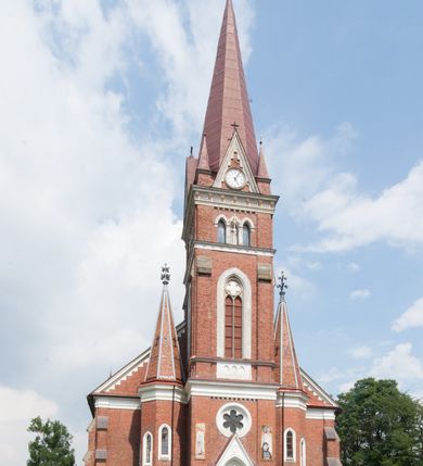 Zdjęcie nr 7: Kościół orientowany, składający się trójnawowej, czteroprzęsłowej pseudohali z transeptem oraz z jednoprzęsłowym, zamkniętym trójbocznie prezbiterium, przy którym od północy usytuowana jest zakrystia, a od południa skarbiec, zamknięte dwubocznie. Od fasady, na przedłużeniu nawy, usytuowana jest czteroboczna wieża, a przy niej ośmioboczne wieżyczki schodowe. Kościół ustawiony jest na wysokim, kamiennym cokole. Wieża trójkondygnacyjna: w dolnej kondygnacji ostrołukowy portal w obramieniu z kolumienkami i wimpergą, nad nim rozeta; w drugiej, ostrołukowe okno z maswerkiem; w trzeciej tryforium. Ściany wieży są zwieńczone szczytami, a wieżyczki schodowe ostrosłupowymi ceglanymi hełmami. Elewacje opięte są przyporami, zwieńczone gzymsem. Okna ostrołukowe z maswerkami, w tynkowanych na biało obramieniach. Dachy dwuspadowe, nad zakrystią i skarbcem pulpitowe, hełm wieży ostrosłupowy; pokrycie blachą. Empora organowa znajduje się w zachodnim przęśle nawy. Sklepienia krzyżowo-żebrowe, przy prezbiterium – gwiaździste. Nawy oddzielone kolumnami o kapitelach pączkowych; na ścianach naw bocznych pilastry. Chór muzyczny na kolumnach z kapitelami kostkowymi. Okna prostokątne zakończone ostrołukowo, w prezbiterium: jednodzielne, usytuowane w trzech ścianach zamknięcia chóru, z witrażami; w korpusie nawowym: trój- i dwudzielne, w pierwszych (wschodnich) trzech przęsłach z witrażami. Żebra sklepienne podkreślone polichromią. Portal główny zdobi tondo z płaskorzeźbą Najświętszego Serca Pana Jezusa.