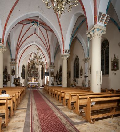 Zdjęcie nr 22: Kościół orientowany, składający się trójnawowej, czteroprzęsłowej pseudohali z transeptem oraz z jednoprzęsłowym, zamkniętym trójbocznie prezbiterium, przy którym od północy usytuowana jest zakrystia, a od południa skarbiec, zamknięte dwubocznie. Od fasady, na przedłużeniu nawy, usytuowana jest czteroboczna wieża, a przy niej ośmioboczne wieżyczki schodowe. Kościół ustawiony jest na wysokim, kamiennym cokole. Wieża trójkondygnacyjna: w dolnej kondygnacji ostrołukowy portal w obramieniu z kolumienkami i wimpergą, nad nim rozeta; w drugiej, ostrołukowe okno z maswerkiem; w trzeciej tryforium. Ściany wieży są zwieńczone szczytami, a wieżyczki schodowe ostrosłupowymi ceglanymi hełmami. Elewacje opięte są przyporami, zwieńczone gzymsem. Okna ostrołukowe z maswerkami, w tynkowanych na biało obramieniach. Dachy dwuspadowe, nad zakrystią i skarbcem pulpitowe, hełm wieży ostrosłupowy; pokrycie blachą. Empora organowa znajduje się w zachodnim przęśle nawy. Sklepienia krzyżowo-żebrowe, przy prezbiterium – gwiaździste. Nawy oddzielone kolumnami o kapitelach pączkowych; na ścianach naw bocznych pilastry. Chór muzyczny na kolumnach z kapitelami kostkowymi. Okna prostokątne zakończone ostrołukowo, w prezbiterium: jednodzielne, usytuowane w trzech ścianach zamknięcia chóru, z witrażami; w korpusie nawowym: trój- i dwudzielne, w pierwszych (wschodnich) trzech przęsłach z witrażami. Żebra sklepienne podkreślone polichromią. Portal główny zdobi tondo z płaskorzeźbą Najświętszego Serca Pana Jezusa.