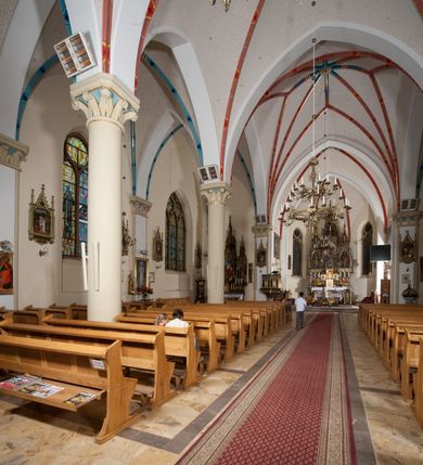 Zdjęcie nr 23: Kościół orientowany, składający się trójnawowej, czteroprzęsłowej pseudohali z transeptem oraz z jednoprzęsłowym, zamkniętym trójbocznie prezbiterium, przy którym od północy usytuowana jest zakrystia, a od południa skarbiec, zamknięte dwubocznie. Od fasady, na przedłużeniu nawy, usytuowana jest czteroboczna wieża, a przy niej ośmioboczne wieżyczki schodowe. Kościół ustawiony jest na wysokim, kamiennym cokole. Wieża trójkondygnacyjna: w dolnej kondygnacji ostrołukowy portal w obramieniu z kolumienkami i wimpergą, nad nim rozeta; w drugiej, ostrołukowe okno z maswerkiem; w trzeciej tryforium. Ściany wieży są zwieńczone szczytami, a wieżyczki schodowe ostrosłupowymi ceglanymi hełmami. Elewacje opięte są przyporami, zwieńczone gzymsem. Okna ostrołukowe z maswerkami, w tynkowanych na biało obramieniach. Dachy dwuspadowe, nad zakrystią i skarbcem pulpitowe, hełm wieży ostrosłupowy; pokrycie blachą. Empora organowa znajduje się w zachodnim przęśle nawy. Sklepienia krzyżowo-żebrowe, przy prezbiterium – gwiaździste. Nawy oddzielone kolumnami o kapitelach pączkowych; na ścianach naw bocznych pilastry. Chór muzyczny na kolumnach z kapitelami kostkowymi. Okna prostokątne zakończone ostrołukowo, w prezbiterium: jednodzielne, usytuowane w trzech ścianach zamknięcia chóru, z witrażami; w korpusie nawowym: trój- i dwudzielne, w pierwszych (wschodnich) trzech przęsłach z witrażami. Żebra sklepienne podkreślone polichromią. Portal główny zdobi tondo z płaskorzeźbą Najświętszego Serca Pana Jezusa.