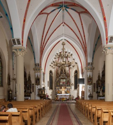 Zdjęcie nr 19: Kościół orientowany, składający się trójnawowej, czteroprzęsłowej pseudohali z transeptem oraz z jednoprzęsłowym, zamkniętym trójbocznie prezbiterium, przy którym od północy usytuowana jest zakrystia, a od południa skarbiec, zamknięte dwubocznie. Od fasady, na przedłużeniu nawy, usytuowana jest czteroboczna wieża, a przy niej ośmioboczne wieżyczki schodowe. Kościół ustawiony jest na wysokim, kamiennym cokole. Wieża trójkondygnacyjna: w dolnej kondygnacji ostrołukowy portal w obramieniu z kolumienkami i wimpergą, nad nim rozeta; w drugiej, ostrołukowe okno z maswerkiem; w trzeciej tryforium. Ściany wieży są zwieńczone szczytami, a wieżyczki schodowe ostrosłupowymi ceglanymi hełmami. Elewacje opięte są przyporami, zwieńczone gzymsem. Okna ostrołukowe z maswerkami, w tynkowanych na biało obramieniach. Dachy dwuspadowe, nad zakrystią i skarbcem pulpitowe, hełm wieży ostrosłupowy; pokrycie blachą. Empora organowa znajduje się w zachodnim przęśle nawy. Sklepienia krzyżowo-żebrowe, przy prezbiterium – gwiaździste. Nawy oddzielone kolumnami o kapitelach pączkowych; na ścianach naw bocznych pilastry. Chór muzyczny na kolumnach z kapitelami kostkowymi. Okna prostokątne zakończone ostrołukowo, w prezbiterium: jednodzielne, usytuowane w trzech ścianach zamknięcia chóru, z witrażami; w korpusie nawowym: trój- i dwudzielne, w pierwszych (wschodnich) trzech przęsłach z witrażami. Żebra sklepienne podkreślone polichromią. Portal główny zdobi tondo z płaskorzeźbą Najświętszego Serca Pana Jezusa.