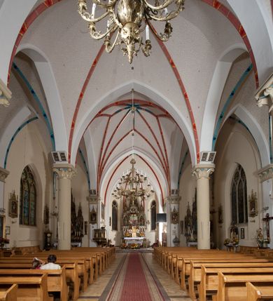 Zdjęcie nr 18: Kościół orientowany, składający się trójnawowej, czteroprzęsłowej pseudohali z transeptem oraz z jednoprzęsłowym, zamkniętym trójbocznie prezbiterium, przy którym od północy usytuowana jest zakrystia, a od południa skarbiec, zamknięte dwubocznie. Od fasady, na przedłużeniu nawy, usytuowana jest czteroboczna wieża, a przy niej ośmioboczne wieżyczki schodowe. Kościół ustawiony jest na wysokim, kamiennym cokole. Wieża trójkondygnacyjna: w dolnej kondygnacji ostrołukowy portal w obramieniu z kolumienkami i wimpergą, nad nim rozeta; w drugiej, ostrołukowe okno z maswerkiem; w trzeciej tryforium. Ściany wieży są zwieńczone szczytami, a wieżyczki schodowe ostrosłupowymi ceglanymi hełmami. Elewacje opięte są przyporami, zwieńczone gzymsem. Okna ostrołukowe z maswerkami, w tynkowanych na biało obramieniach. Dachy dwuspadowe, nad zakrystią i skarbcem pulpitowe, hełm wieży ostrosłupowy; pokrycie blachą. Empora organowa znajduje się w zachodnim przęśle nawy. Sklepienia krzyżowo-żebrowe, przy prezbiterium – gwiaździste. Nawy oddzielone kolumnami o kapitelach pączkowych; na ścianach naw bocznych pilastry. Chór muzyczny na kolumnach z kapitelami kostkowymi. Okna prostokątne zakończone ostrołukowo, w prezbiterium: jednodzielne, usytuowane w trzech ścianach zamknięcia chóru, z witrażami; w korpusie nawowym: trój- i dwudzielne, w pierwszych (wschodnich) trzech przęsłach z witrażami. Żebra sklepienne podkreślone polichromią. Portal główny zdobi tondo z płaskorzeźbą Najświętszego Serca Pana Jezusa.