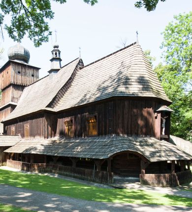 Zdjęcie nr 15: Kościół orientowany, drewniany, na podmurowaniu, o konstrukcji zrębowej, z wieżą o konstrukcji słupowo-ramowej. Składa się z prostokątnej nawy, do której od wschodu przylega węższe prezbiterium zamknięte trójbocznie. Do niego od północy dobudowano prostokątną zakrystię. Do nawy od zachodu przylega wieża na rzucie kwadratu, o ścianach pochyłych, rozdzielona na kondygnacje daszkiem; zwieńczona nadwieszoną izbicą szalowaną pionowymi deskami wyciętymi dołem w ozdobną koronkę; w ścianach izbicy po dwa małe okienka. 
Kościół jednonawowy, z węższym prezbiterium oddzielonym ścianą tęczową. Otwór tęczowy podwójny, górny mniejszy, w strefie sklepień, dolny większy, wycięty w zrębie. Na podniebiu dolnego łuku napis „TEN KOŚCIÓŁ ZAŁOŻONY RP 1789 BENEDYKOWANY RP 1792 MALOWANY RP 1930”. Ściany gładkie, pokryte dekoracją malarską imitującą detale architektoniczne: kolumny, belkowanie, obramienia okien, plafony wypełnione rzeźbiarską dekoracją; między nimi postacie świętych. W nawie od zachodu chór muzyczny wsparty na dwóch, profilowanych słupach, z parapetem wybrzuszonym pośrodku. Nawa i prezbiterium nakryte pozornym sklepieniem kolebkowym z płaskimi odcinkami stropowymi po bokach. 
W nawie głównej cztery okna, w prezbiterium dwa, wszystkie w kształcie stojącego prostokąta; w dolnej kondygnacji wieży dwa okna w kształcie leżącego prostokąta. Wejście główne od zachodu, kolejne od południa, oba portale zamknięte od góry łukiem „w ośli grzbiet”; portal z prezbiterium do zakrystii.  
Kościół obiegają soboty, czyli rodzaj podcieni, zamkniętych wokół wieży, otwartych na pozostałej długości; z kruchtami od zachodu i od południa; cztery kwadratowe okienka w sobotach od zachodu. 
Ściany na zewnątrz kościoła pobite deskami. Nad nawą główną dach dwuspadowy, nad prezbiterium wielopołaciowy, przedłużony od północy na zakrystię. Na dachu nawy zwężająca się ku górze wieżyczka na sygnaturkę, która przechodzi w latarnię o cebulastym zakończeniu. Wieżę zachodnią wieńczy hełm złożony z niskiego dachu namiotowego i nasadzonej na niego bani z kulą i krzyżem. Soboty nakryto dachem pulpitowym, wygiętym przy ścianie wschodniej zakrystii łukowo ku górze po to, aby lepiej ją doświetlić. Dachy kryte gontami, hełmy wież blachą. 
