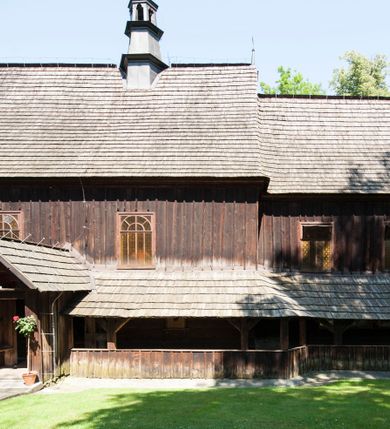 Zdjęcie nr 8: Kościół orientowany, drewniany, na podmurowaniu, o konstrukcji zrębowej, z wieżą o konstrukcji słupowo-ramowej. Składa się z prostokątnej nawy, do której od wschodu przylega węższe prezbiterium zamknięte trójbocznie. Do niego od północy dobudowano prostokątną zakrystię. Do nawy od zachodu przylega wieża na rzucie kwadratu, o ścianach pochyłych, rozdzielona na kondygnacje daszkiem; zwieńczona nadwieszoną izbicą szalowaną pionowymi deskami wyciętymi dołem w ozdobną koronkę; w ścianach izbicy po dwa małe okienka. 
Kościół jednonawowy, z węższym prezbiterium oddzielonym ścianą tęczową. Otwór tęczowy podwójny, górny mniejszy, w strefie sklepień, dolny większy, wycięty w zrębie. Na podniebiu dolnego łuku napis „TEN KOŚCIÓŁ ZAŁOŻONY RP 1789 BENEDYKOWANY RP 1792 MALOWANY RP 1930”. Ściany gładkie, pokryte dekoracją malarską imitującą detale architektoniczne: kolumny, belkowanie, obramienia okien, plafony wypełnione rzeźbiarską dekoracją; między nimi postacie świętych. W nawie od zachodu chór muzyczny wsparty na dwóch, profilowanych słupach, z parapetem wybrzuszonym pośrodku. Nawa i prezbiterium nakryte pozornym sklepieniem kolebkowym z płaskimi odcinkami stropowymi po bokach. 
W nawie głównej cztery okna, w prezbiterium dwa, wszystkie w kształcie stojącego prostokąta; w dolnej kondygnacji wieży dwa okna w kształcie leżącego prostokąta. Wejście główne od zachodu, kolejne od południa, oba portale zamknięte od góry łukiem „w ośli grzbiet”; portal z prezbiterium do zakrystii.  
Kościół obiegają soboty, czyli rodzaj podcieni, zamkniętych wokół wieży, otwartych na pozostałej długości; z kruchtami od zachodu i od południa; cztery kwadratowe okienka w sobotach od zachodu. 
Ściany na zewnątrz kościoła pobite deskami. Nad nawą główną dach dwuspadowy, nad prezbiterium wielopołaciowy, przedłużony od północy na zakrystię. Na dachu nawy zwężająca się ku górze wieżyczka na sygnaturkę, która przechodzi w latarnię o cebulastym zakończeniu. Wieżę zachodnią wieńczy hełm złożony z niskiego dachu namiotowego i nasadzonej na niego bani z kulą i krzyżem. Soboty nakryto dachem pulpitowym, wygiętym przy ścianie wschodniej zakrystii łukowo ku górze po to, aby lepiej ją doświetlić. Dachy kryte gontami, hełmy wież blachą. 
