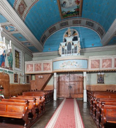 Zdjęcie nr 60: Kościół orientowany, drewniany, na podmurowaniu, o konstrukcji zrębowej, z wieżą o konstrukcji słupowo-ramowej. Składa się z prostokątnej nawy, do której od wschodu przylega węższe prezbiterium zamknięte trójbocznie. Do niego od północy dobudowano prostokątną zakrystię. Do nawy od zachodu przylega wieża na rzucie kwadratu, o ścianach pochyłych, rozdzielona na kondygnacje daszkiem; zwieńczona nadwieszoną izbicą szalowaną pionowymi deskami wyciętymi dołem w ozdobną koronkę; w ścianach izbicy po dwa małe okienka. 
Kościół jednonawowy, z węższym prezbiterium oddzielonym ścianą tęczową. Otwór tęczowy podwójny, górny mniejszy, w strefie sklepień, dolny większy, wycięty w zrębie. Na podniebiu dolnego łuku napis „TEN KOŚCIÓŁ ZAŁOŻONY RP 1789 BENEDYKOWANY RP 1792 MALOWANY RP 1930”. Ściany gładkie, pokryte dekoracją malarską imitującą detale architektoniczne: kolumny, belkowanie, obramienia okien, plafony wypełnione rzeźbiarską dekoracją; między nimi postacie świętych. W nawie od zachodu chór muzyczny wsparty na dwóch, profilowanych słupach, z parapetem wybrzuszonym pośrodku. Nawa i prezbiterium nakryte pozornym sklepieniem kolebkowym z płaskimi odcinkami stropowymi po bokach. 
W nawie głównej cztery okna, w prezbiterium dwa, wszystkie w kształcie stojącego prostokąta; w dolnej kondygnacji wieży dwa okna w kształcie leżącego prostokąta. Wejście główne od zachodu, kolejne od południa, oba portale zamknięte od góry łukiem „w ośli grzbiet”; portal z prezbiterium do zakrystii.  
Kościół obiegają soboty, czyli rodzaj podcieni, zamkniętych wokół wieży, otwartych na pozostałej długości; z kruchtami od zachodu i od południa; cztery kwadratowe okienka w sobotach od zachodu. 
Ściany na zewnątrz kościoła pobite deskami. Nad nawą główną dach dwuspadowy, nad prezbiterium wielopołaciowy, przedłużony od północy na zakrystię. Na dachu nawy zwężająca się ku górze wieżyczka na sygnaturkę, która przechodzi w latarnię o cebulastym zakończeniu. Wieżę zachodnią wieńczy hełm złożony z niskiego dachu namiotowego i nasadzonej na niego bani z kulą i krzyżem. Soboty nakryto dachem pulpitowym, wygiętym przy ścianie wschodniej zakrystii łukowo ku górze po to, aby lepiej ją doświetlić. Dachy kryte gontami, hełmy wież blachą. 
