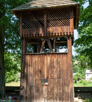 Zdjęcie nr 32: Kościół orientowany, drewniany, na podmurowaniu, o konstrukcji zrębowej, z wieżą o konstrukcji słupowo-ramowej. Składa się z prostokątnej nawy, do której od wschodu przylega węższe prezbiterium zamknięte trójbocznie. Do niego od północy dobudowano prostokątną zakrystię. Do nawy od zachodu przylega wieża na rzucie kwadratu, o ścianach pochyłych, rozdzielona na kondygnacje daszkiem; zwieńczona nadwieszoną izbicą szalowaną pionowymi deskami wyciętymi dołem w ozdobną koronkę; w ścianach izbicy po dwa małe okienka. 
Kościół jednonawowy, z węższym prezbiterium oddzielonym ścianą tęczową. Otwór tęczowy podwójny, górny mniejszy, w strefie sklepień, dolny większy, wycięty w zrębie. Na podniebiu dolnego łuku napis „TEN KOŚCIÓŁ ZAŁOŻONY RP 1789 BENEDYKOWANY RP 1792 MALOWANY RP 1930”. Ściany gładkie, pokryte dekoracją malarską imitującą detale architektoniczne: kolumny, belkowanie, obramienia okien, plafony wypełnione rzeźbiarską dekoracją; między nimi postacie świętych. W nawie od zachodu chór muzyczny wsparty na dwóch, profilowanych słupach, z parapetem wybrzuszonym pośrodku. Nawa i prezbiterium nakryte pozornym sklepieniem kolebkowym z płaskimi odcinkami stropowymi po bokach. 
W nawie głównej cztery okna, w prezbiterium dwa, wszystkie w kształcie stojącego prostokąta; w dolnej kondygnacji wieży dwa okna w kształcie leżącego prostokąta. Wejście główne od zachodu, kolejne od południa, oba portale zamknięte od góry łukiem „w ośli grzbiet”; portal z prezbiterium do zakrystii.  
Kościół obiegają soboty, czyli rodzaj podcieni, zamkniętych wokół wieży, otwartych na pozostałej długości; z kruchtami od zachodu i od południa; cztery kwadratowe okienka w sobotach od zachodu. 
Ściany na zewnątrz kościoła pobite deskami. Nad nawą główną dach dwuspadowy, nad prezbiterium wielopołaciowy, przedłużony od północy na zakrystię. Na dachu nawy zwężająca się ku górze wieżyczka na sygnaturkę, która przechodzi w latarnię o cebulastym zakończeniu. Wieżę zachodnią wieńczy hełm złożony z niskiego dachu namiotowego i nasadzonej na niego bani z kulą i krzyżem. Soboty nakryto dachem pulpitowym, wygiętym przy ścianie wschodniej zakrystii łukowo ku górze po to, aby lepiej ją doświetlić. Dachy kryte gontami, hełmy wież blachą. 
