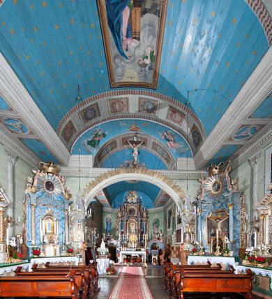 Zdjęcie nr 45: Kościół orientowany, drewniany, na podmurowaniu, o konstrukcji zrębowej, z wieżą o konstrukcji słupowo-ramowej. Składa się z prostokątnej nawy, do której od wschodu przylega węższe prezbiterium zamknięte trójbocznie. Do niego od północy dobudowano prostokątną zakrystię. Do nawy od zachodu przylega wieża na rzucie kwadratu, o ścianach pochyłych, rozdzielona na kondygnacje daszkiem; zwieńczona nadwieszoną izbicą szalowaną pionowymi deskami wyciętymi dołem w ozdobną koronkę; w ścianach izbicy po dwa małe okienka. 
Kościół jednonawowy, z węższym prezbiterium oddzielonym ścianą tęczową. Otwór tęczowy podwójny, górny mniejszy, w strefie sklepień, dolny większy, wycięty w zrębie. Na podniebiu dolnego łuku napis „TEN KOŚCIÓŁ ZAŁOŻONY RP 1789 BENEDYKOWANY RP 1792 MALOWANY RP 1930”. Ściany gładkie, pokryte dekoracją malarską imitującą detale architektoniczne: kolumny, belkowanie, obramienia okien, plafony wypełnione rzeźbiarską dekoracją; między nimi postacie świętych. W nawie od zachodu chór muzyczny wsparty na dwóch, profilowanych słupach, z parapetem wybrzuszonym pośrodku. Nawa i prezbiterium nakryte pozornym sklepieniem kolebkowym z płaskimi odcinkami stropowymi po bokach. 
W nawie głównej cztery okna, w prezbiterium dwa, wszystkie w kształcie stojącego prostokąta; w dolnej kondygnacji wieży dwa okna w kształcie leżącego prostokąta. Wejście główne od zachodu, kolejne od południa, oba portale zamknięte od góry łukiem „w ośli grzbiet”; portal z prezbiterium do zakrystii.  
Kościół obiegają soboty, czyli rodzaj podcieni, zamkniętych wokół wieży, otwartych na pozostałej długości; z kruchtami od zachodu i od południa; cztery kwadratowe okienka w sobotach od zachodu. 
Ściany na zewnątrz kościoła pobite deskami. Nad nawą główną dach dwuspadowy, nad prezbiterium wielopołaciowy, przedłużony od północy na zakrystię. Na dachu nawy zwężająca się ku górze wieżyczka na sygnaturkę, która przechodzi w latarnię o cebulastym zakończeniu. Wieżę zachodnią wieńczy hełm złożony z niskiego dachu namiotowego i nasadzonej na niego bani z kulą i krzyżem. Soboty nakryto dachem pulpitowym, wygiętym przy ścianie wschodniej zakrystii łukowo ku górze po to, aby lepiej ją doświetlić. Dachy kryte gontami, hełmy wież blachą. 
