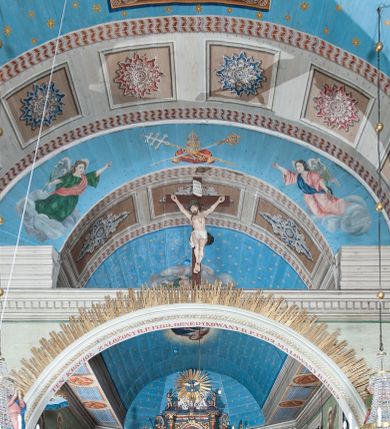 Zdjęcie nr 63: Kościół orientowany, drewniany, na podmurowaniu, o konstrukcji zrębowej, z wieżą o konstrukcji słupowo-ramowej. Składa się z prostokątnej nawy, do której od wschodu przylega węższe prezbiterium zamknięte trójbocznie. Do niego od północy dobudowano prostokątną zakrystię. Do nawy od zachodu przylega wieża na rzucie kwadratu, o ścianach pochyłych, rozdzielona na kondygnacje daszkiem; zwieńczona nadwieszoną izbicą szalowaną pionowymi deskami wyciętymi dołem w ozdobną koronkę; w ścianach izbicy po dwa małe okienka. 
Kościół jednonawowy, z węższym prezbiterium oddzielonym ścianą tęczową. Otwór tęczowy podwójny, górny mniejszy, w strefie sklepień, dolny większy, wycięty w zrębie. Na podniebiu dolnego łuku napis „TEN KOŚCIÓŁ ZAŁOŻONY RP 1789 BENEDYKOWANY RP 1792 MALOWANY RP 1930”. Ściany gładkie, pokryte dekoracją malarską imitującą detale architektoniczne: kolumny, belkowanie, obramienia okien, plafony wypełnione rzeźbiarską dekoracją; między nimi postacie świętych. W nawie od zachodu chór muzyczny wsparty na dwóch, profilowanych słupach, z parapetem wybrzuszonym pośrodku. Nawa i prezbiterium nakryte pozornym sklepieniem kolebkowym z płaskimi odcinkami stropowymi po bokach. 
W nawie głównej cztery okna, w prezbiterium dwa, wszystkie w kształcie stojącego prostokąta; w dolnej kondygnacji wieży dwa okna w kształcie leżącego prostokąta. Wejście główne od zachodu, kolejne od południa, oba portale zamknięte od góry łukiem „w ośli grzbiet”; portal z prezbiterium do zakrystii.  
Kościół obiegają soboty, czyli rodzaj podcieni, zamkniętych wokół wieży, otwartych na pozostałej długości; z kruchtami od zachodu i od południa; cztery kwadratowe okienka w sobotach od zachodu. 
Ściany na zewnątrz kościoła pobite deskami. Nad nawą główną dach dwuspadowy, nad prezbiterium wielopołaciowy, przedłużony od północy na zakrystię. Na dachu nawy zwężająca się ku górze wieżyczka na sygnaturkę, która przechodzi w latarnię o cebulastym zakończeniu. Wieżę zachodnią wieńczy hełm złożony z niskiego dachu namiotowego i nasadzonej na niego bani z kulą i krzyżem. Soboty nakryto dachem pulpitowym, wygiętym przy ścianie wschodniej zakrystii łukowo ku górze po to, aby lepiej ją doświetlić. Dachy kryte gontami, hełmy wież blachą. 
