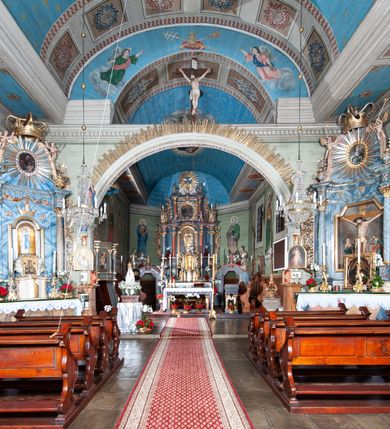 Zdjęcie nr 47: Kościół orientowany, drewniany, na podmurowaniu, o konstrukcji zrębowej, z wieżą o konstrukcji słupowo-ramowej. Składa się z prostokątnej nawy, do której od wschodu przylega węższe prezbiterium zamknięte trójbocznie. Do niego od północy dobudowano prostokątną zakrystię. Do nawy od zachodu przylega wieża na rzucie kwadratu, o ścianach pochyłych, rozdzielona na kondygnacje daszkiem; zwieńczona nadwieszoną izbicą szalowaną pionowymi deskami wyciętymi dołem w ozdobną koronkę; w ścianach izbicy po dwa małe okienka. 
Kościół jednonawowy, z węższym prezbiterium oddzielonym ścianą tęczową. Otwór tęczowy podwójny, górny mniejszy, w strefie sklepień, dolny większy, wycięty w zrębie. Na podniebiu dolnego łuku napis „TEN KOŚCIÓŁ ZAŁOŻONY RP 1789 BENEDYKOWANY RP 1792 MALOWANY RP 1930”. Ściany gładkie, pokryte dekoracją malarską imitującą detale architektoniczne: kolumny, belkowanie, obramienia okien, plafony wypełnione rzeźbiarską dekoracją; między nimi postacie świętych. W nawie od zachodu chór muzyczny wsparty na dwóch, profilowanych słupach, z parapetem wybrzuszonym pośrodku. Nawa i prezbiterium nakryte pozornym sklepieniem kolebkowym z płaskimi odcinkami stropowymi po bokach. 
W nawie głównej cztery okna, w prezbiterium dwa, wszystkie w kształcie stojącego prostokąta; w dolnej kondygnacji wieży dwa okna w kształcie leżącego prostokąta. Wejście główne od zachodu, kolejne od południa, oba portale zamknięte od góry łukiem „w ośli grzbiet”; portal z prezbiterium do zakrystii.  
Kościół obiegają soboty, czyli rodzaj podcieni, zamkniętych wokół wieży, otwartych na pozostałej długości; z kruchtami od zachodu i od południa; cztery kwadratowe okienka w sobotach od zachodu. 
Ściany na zewnątrz kościoła pobite deskami. Nad nawą główną dach dwuspadowy, nad prezbiterium wielopołaciowy, przedłużony od północy na zakrystię. Na dachu nawy zwężająca się ku górze wieżyczka na sygnaturkę, która przechodzi w latarnię o cebulastym zakończeniu. Wieżę zachodnią wieńczy hełm złożony z niskiego dachu namiotowego i nasadzonej na niego bani z kulą i krzyżem. Soboty nakryto dachem pulpitowym, wygiętym przy ścianie wschodniej zakrystii łukowo ku górze po to, aby lepiej ją doświetlić. Dachy kryte gontami, hełmy wież blachą. 
