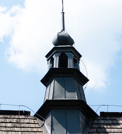 Zdjęcie nr 31: Kościół orientowany, drewniany, na podmurowaniu, o konstrukcji zrębowej, z wieżą o konstrukcji słupowo-ramowej. Składa się z prostokątnej nawy, do której od wschodu przylega węższe prezbiterium zamknięte trójbocznie. Do niego od północy dobudowano prostokątną zakrystię. Do nawy od zachodu przylega wieża na rzucie kwadratu, o ścianach pochyłych, rozdzielona na kondygnacje daszkiem; zwieńczona nadwieszoną izbicą szalowaną pionowymi deskami wyciętymi dołem w ozdobną koronkę; w ścianach izbicy po dwa małe okienka. 
Kościół jednonawowy, z węższym prezbiterium oddzielonym ścianą tęczową. Otwór tęczowy podwójny, górny mniejszy, w strefie sklepień, dolny większy, wycięty w zrębie. Na podniebiu dolnego łuku napis „TEN KOŚCIÓŁ ZAŁOŻONY RP 1789 BENEDYKOWANY RP 1792 MALOWANY RP 1930”. Ściany gładkie, pokryte dekoracją malarską imitującą detale architektoniczne: kolumny, belkowanie, obramienia okien, plafony wypełnione rzeźbiarską dekoracją; między nimi postacie świętych. W nawie od zachodu chór muzyczny wsparty na dwóch, profilowanych słupach, z parapetem wybrzuszonym pośrodku. Nawa i prezbiterium nakryte pozornym sklepieniem kolebkowym z płaskimi odcinkami stropowymi po bokach. 
W nawie głównej cztery okna, w prezbiterium dwa, wszystkie w kształcie stojącego prostokąta; w dolnej kondygnacji wieży dwa okna w kształcie leżącego prostokąta. Wejście główne od zachodu, kolejne od południa, oba portale zamknięte od góry łukiem „w ośli grzbiet”; portal z prezbiterium do zakrystii.  
Kościół obiegają soboty, czyli rodzaj podcieni, zamkniętych wokół wieży, otwartych na pozostałej długości; z kruchtami od zachodu i od południa; cztery kwadratowe okienka w sobotach od zachodu. 
Ściany na zewnątrz kościoła pobite deskami. Nad nawą główną dach dwuspadowy, nad prezbiterium wielopołaciowy, przedłużony od północy na zakrystię. Na dachu nawy zwężająca się ku górze wieżyczka na sygnaturkę, która przechodzi w latarnię o cebulastym zakończeniu. Wieżę zachodnią wieńczy hełm złożony z niskiego dachu namiotowego i nasadzonej na niego bani z kulą i krzyżem. Soboty nakryto dachem pulpitowym, wygiętym przy ścianie wschodniej zakrystii łukowo ku górze po to, aby lepiej ją doświetlić. Dachy kryte gontami, hełmy wież blachą. 
